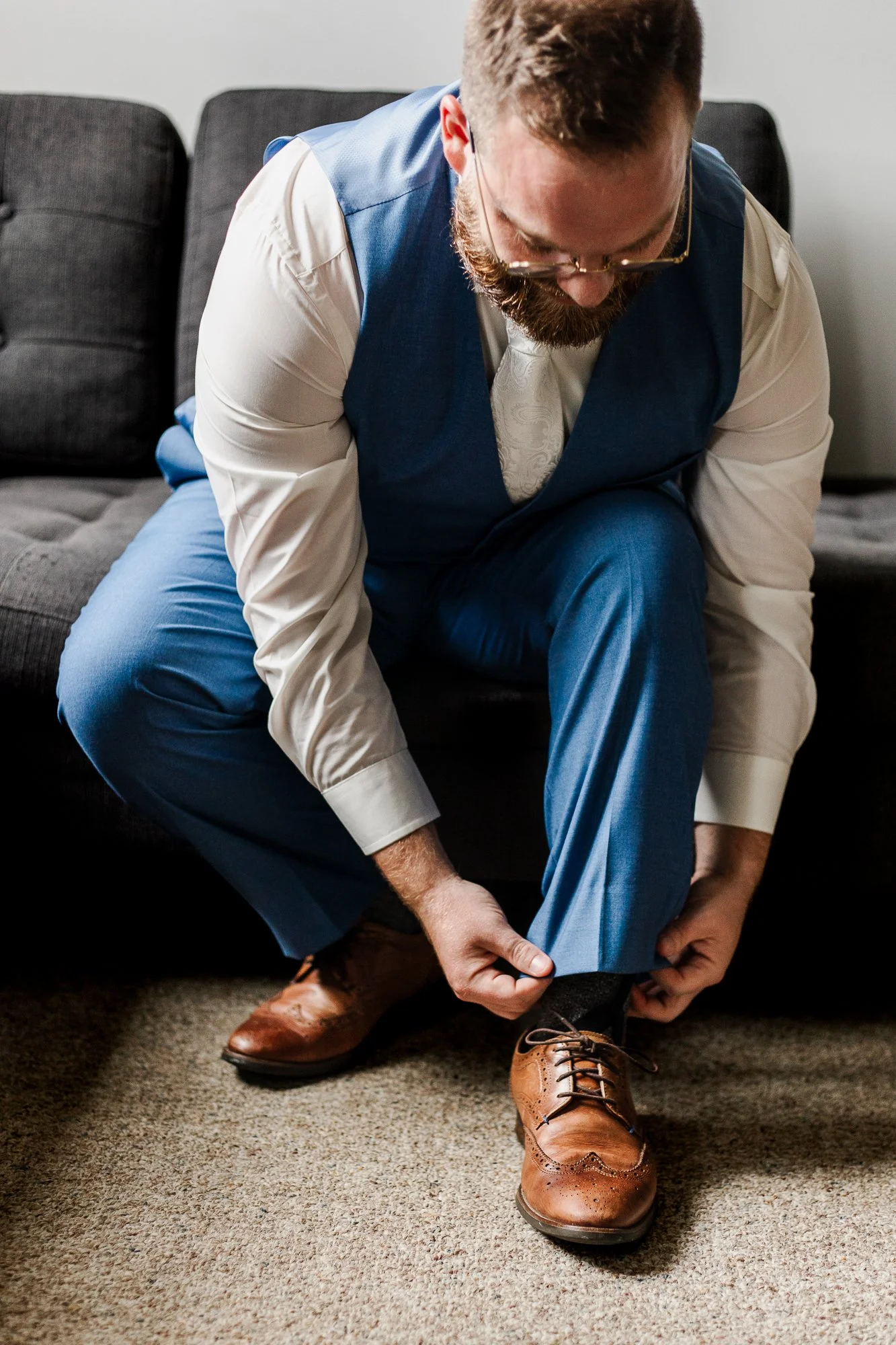 Close up of groom putting shoes on as he's getting ready for his wedding ceremony