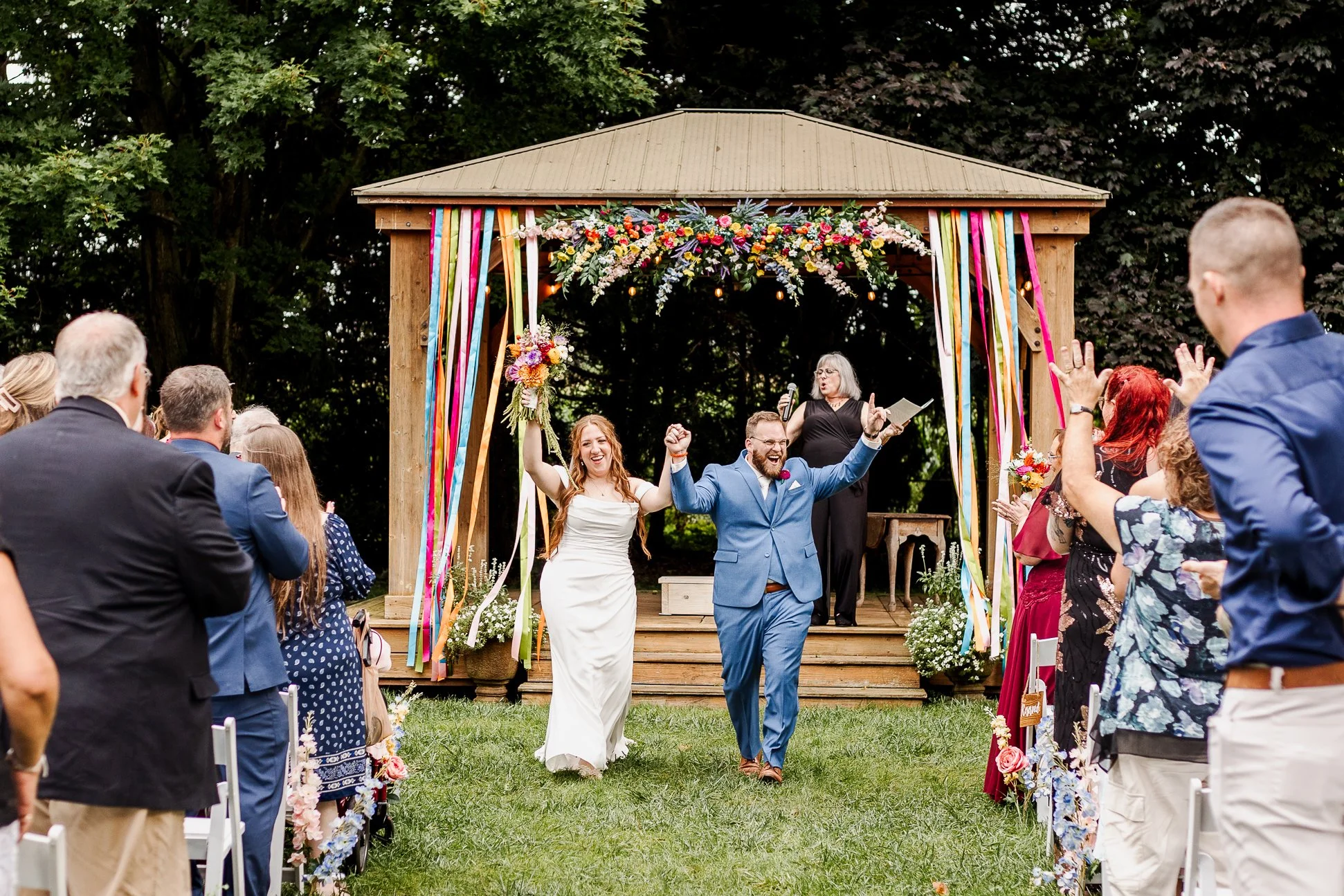 bride and groom during ceremony exit holding hands and raising them in celebration of ceremony being complete