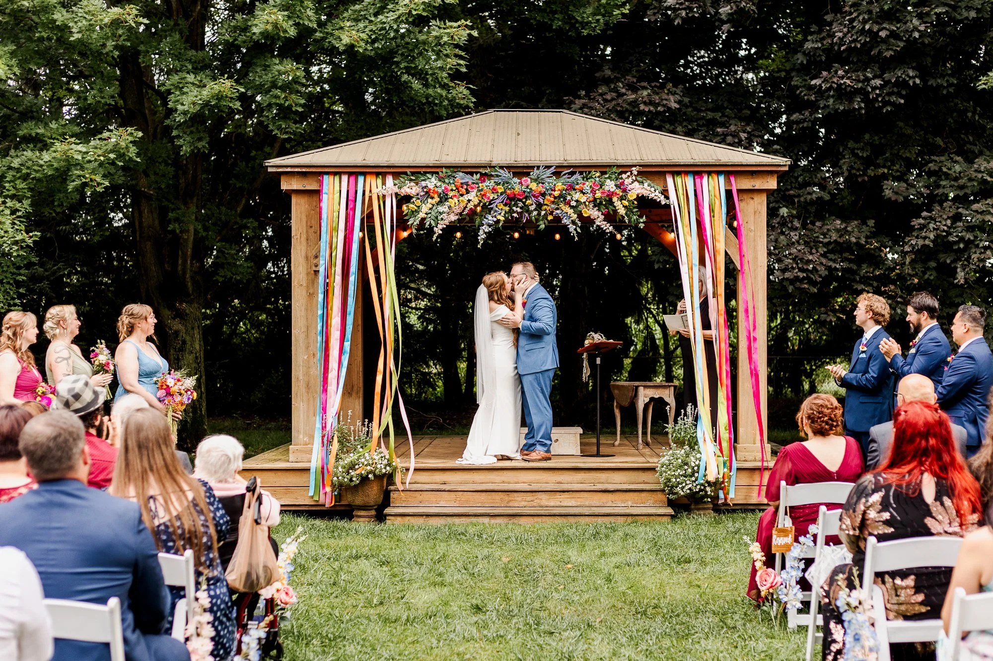 wide shot of bride and groom kissing at the alter during ceremony in gazebo at bloom and bower in rising sun ohio