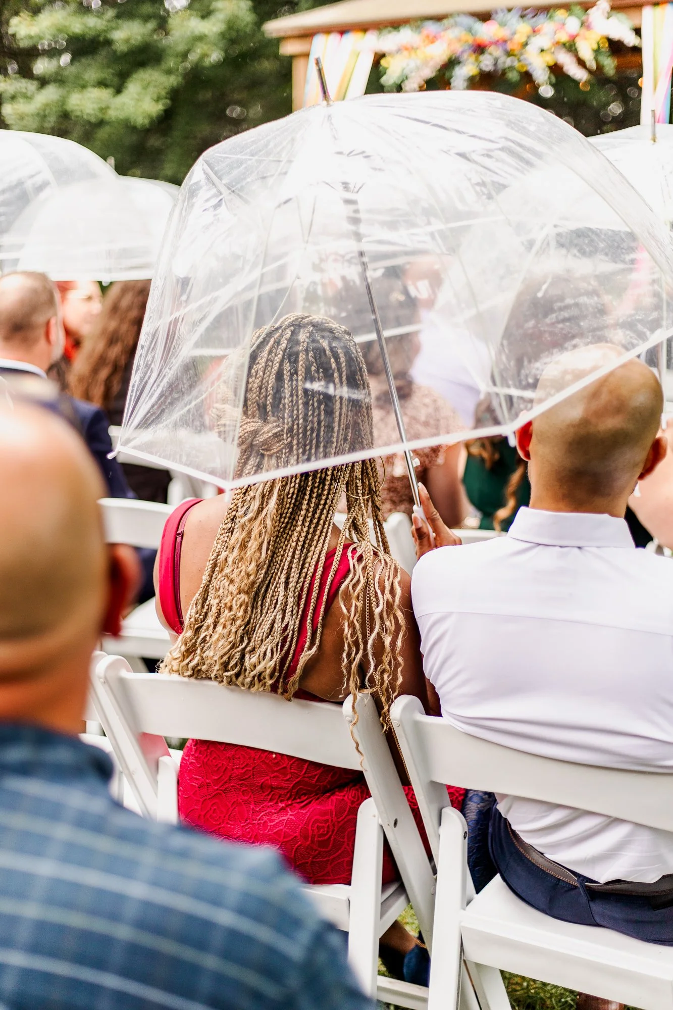 Guests carrying umbrellas while they wait at the ceremony site at bloom and bower in rising sun ohio