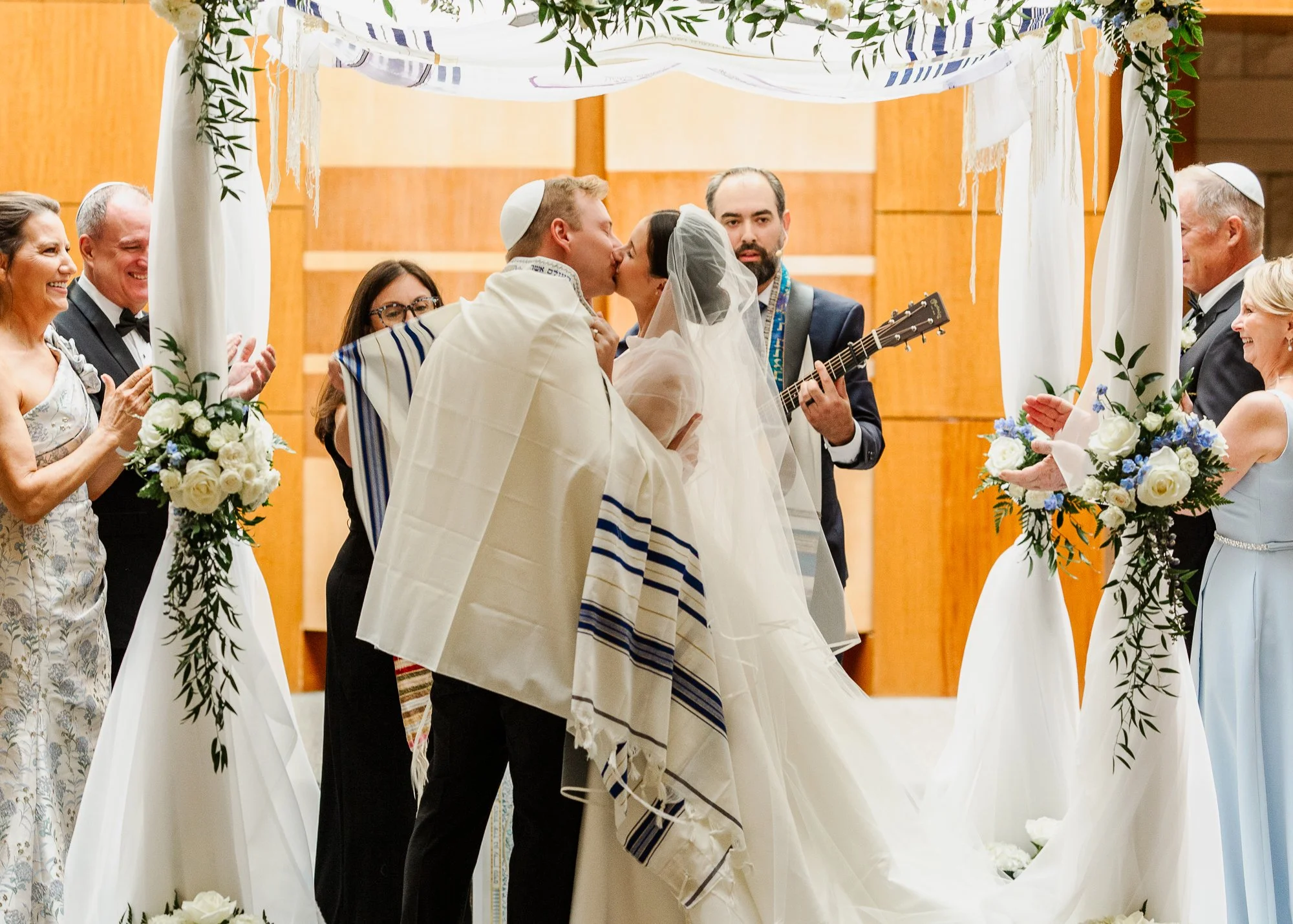 Sarah and Owen kiss during their Jewish wedding ceremony at Temple Shir Shalom