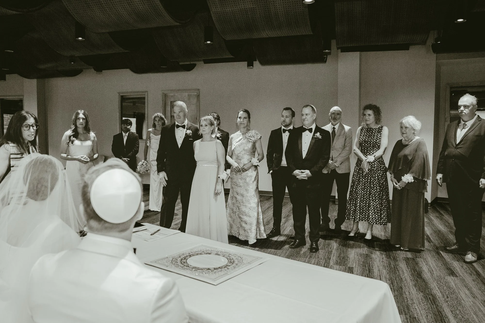 Sarah and Owen signing their ketubah in front of family and friends