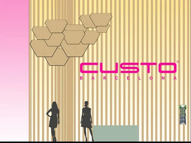 Interior view of a store with vertical striped wallpaper, two mannequins in dresses, hanging geometric decor, and a pink sign that reads 'Custo Barcelona'.