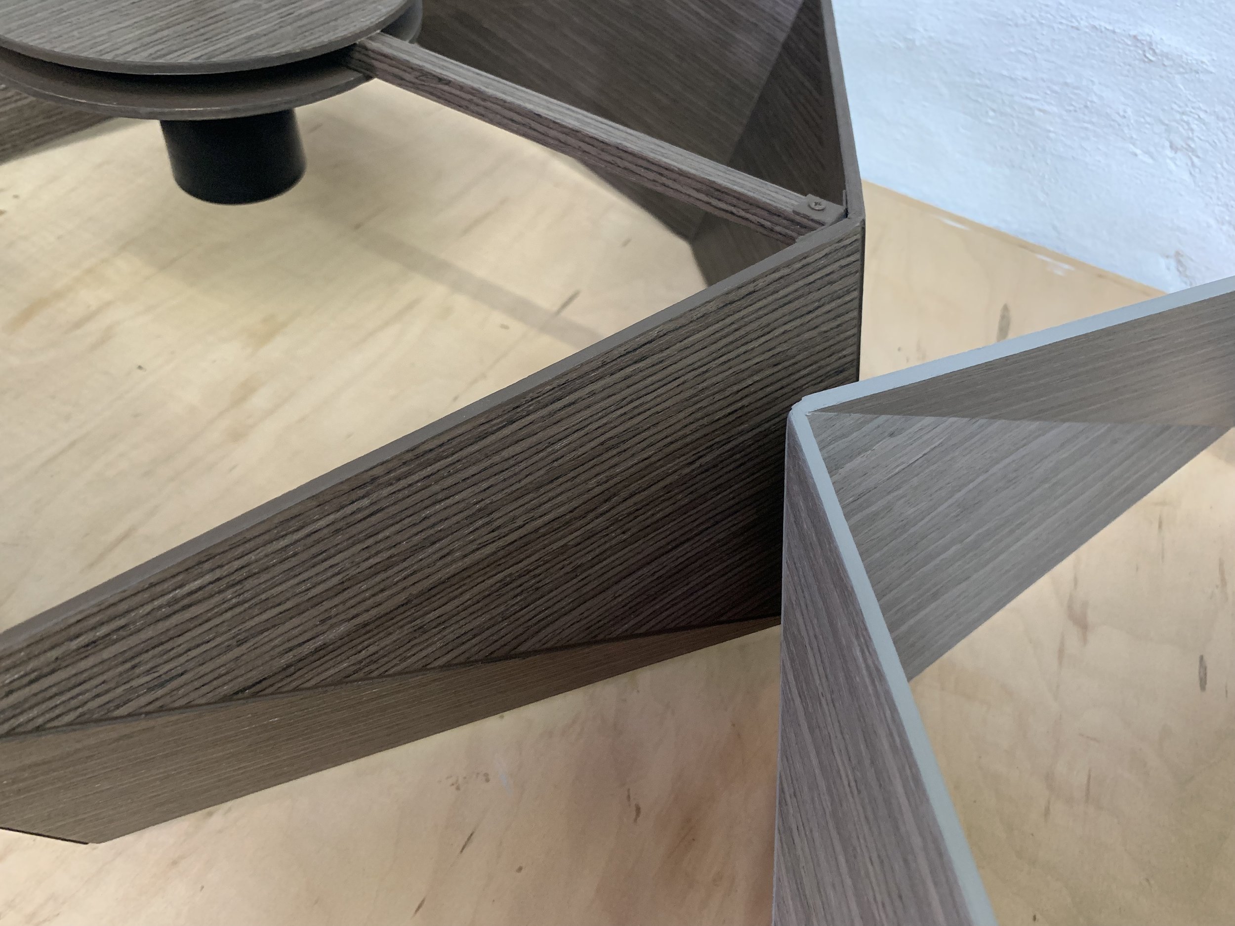 Close-up of a modern wooden display case or furniture with an open top and a removable panel, showing the interior and the wood grain texture.