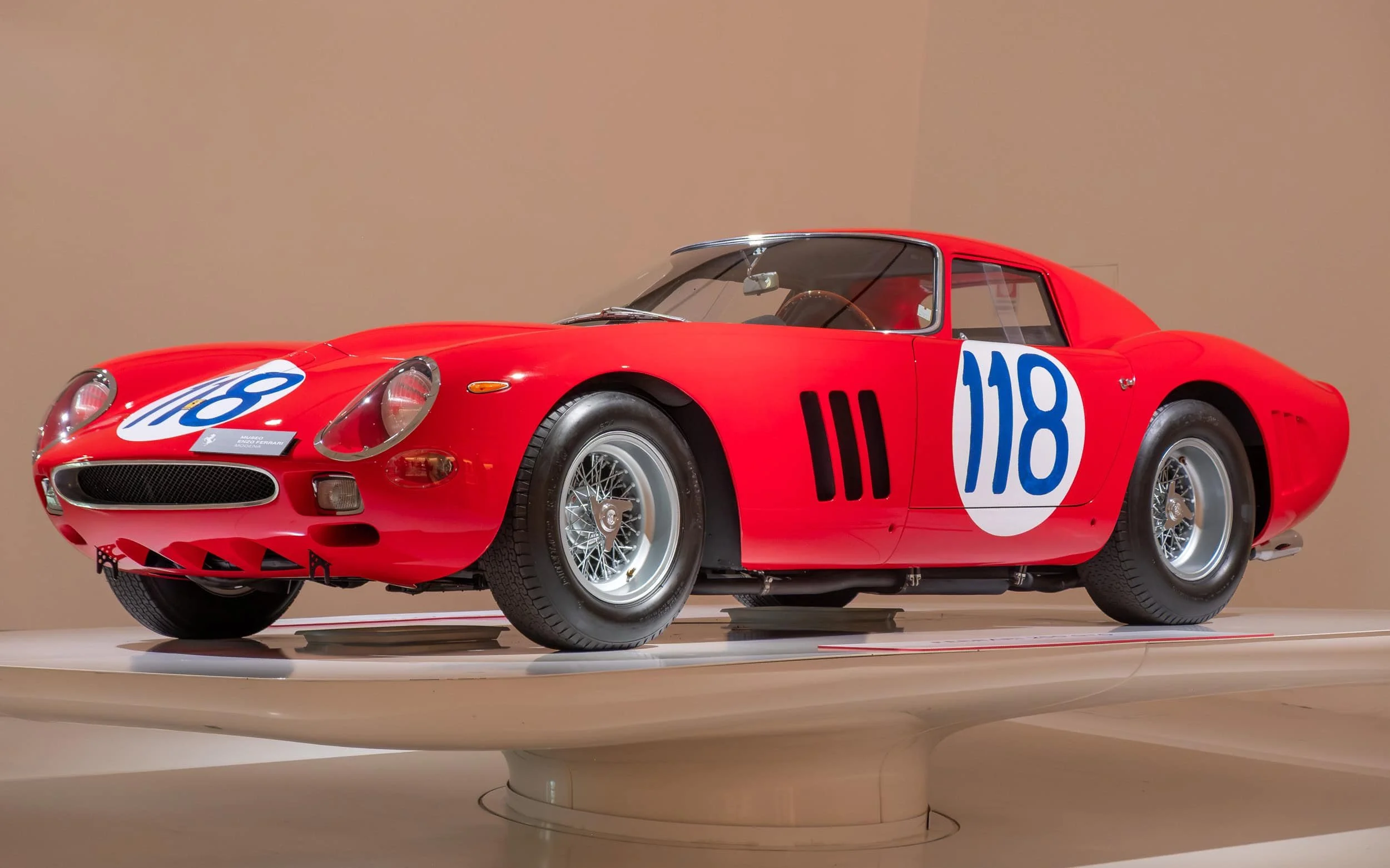 Ferrari 250 GTO classic red race car displayed at the Enzo Ferrari Museum in Modena, Italy, photographed from a front-side angle showing its iconic curves and vintage racing livery.