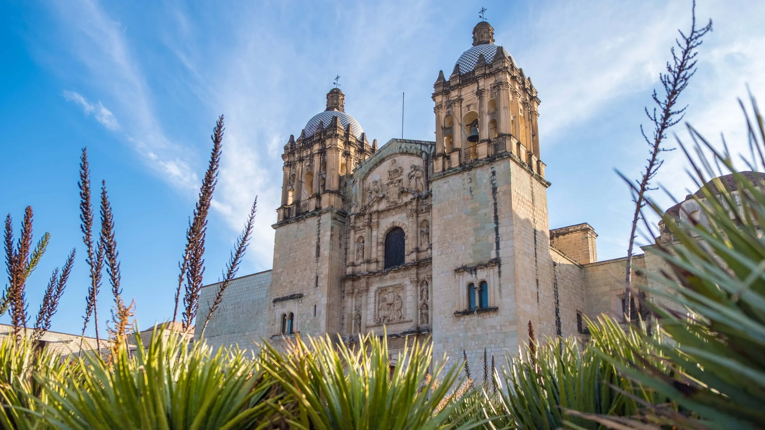 Santo Domingo de Guzmán Church viewed from below at a 45-degree angle in early December morning light.