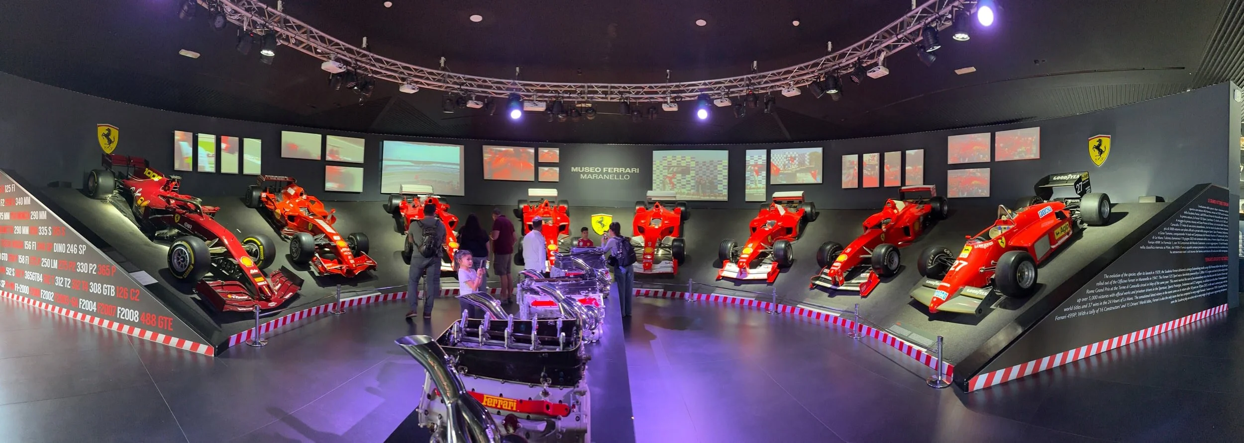 Panoramic view of Ferrari Formula 1 race cars and engines displayed inside the Hall of Victories at the Ferrari Museum in Maranello, Italy, showcasing Ferrari’s Grand Prix racing heritage and championship-winning history.