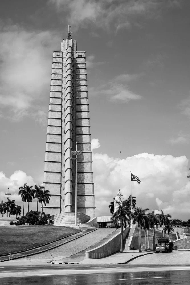 The José Martí Memorial in Havana, Cuba, a tall star-shaped tower rising above the Plaza de la Revolución with surrounding open square and palm trees.