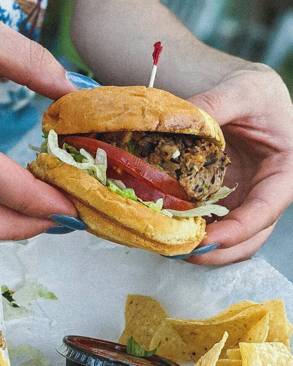 #BurgerADayMay Day 22: &ldquo;We got the Black Bean burger at Pearly&rsquo;s in Clearwater, FL! It&rsquo;s topped with a mango salsa and guacamole, all on a brioche bun. The beach vibes definitely don&rsquo;t hurt either:)&rdquo; - @katie.schneids #g