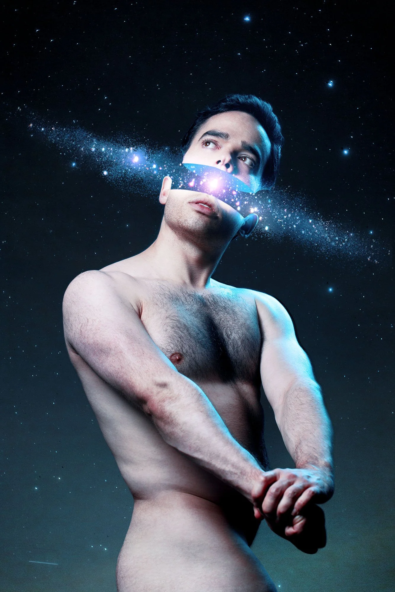 A topless man with dark hair and light skin, with a galaxy pattern across his face and head, standing against a starry night sky background.