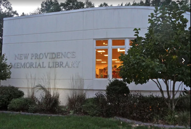 solid white exterior wall of a one-storey building that says New Providence Memorial Library