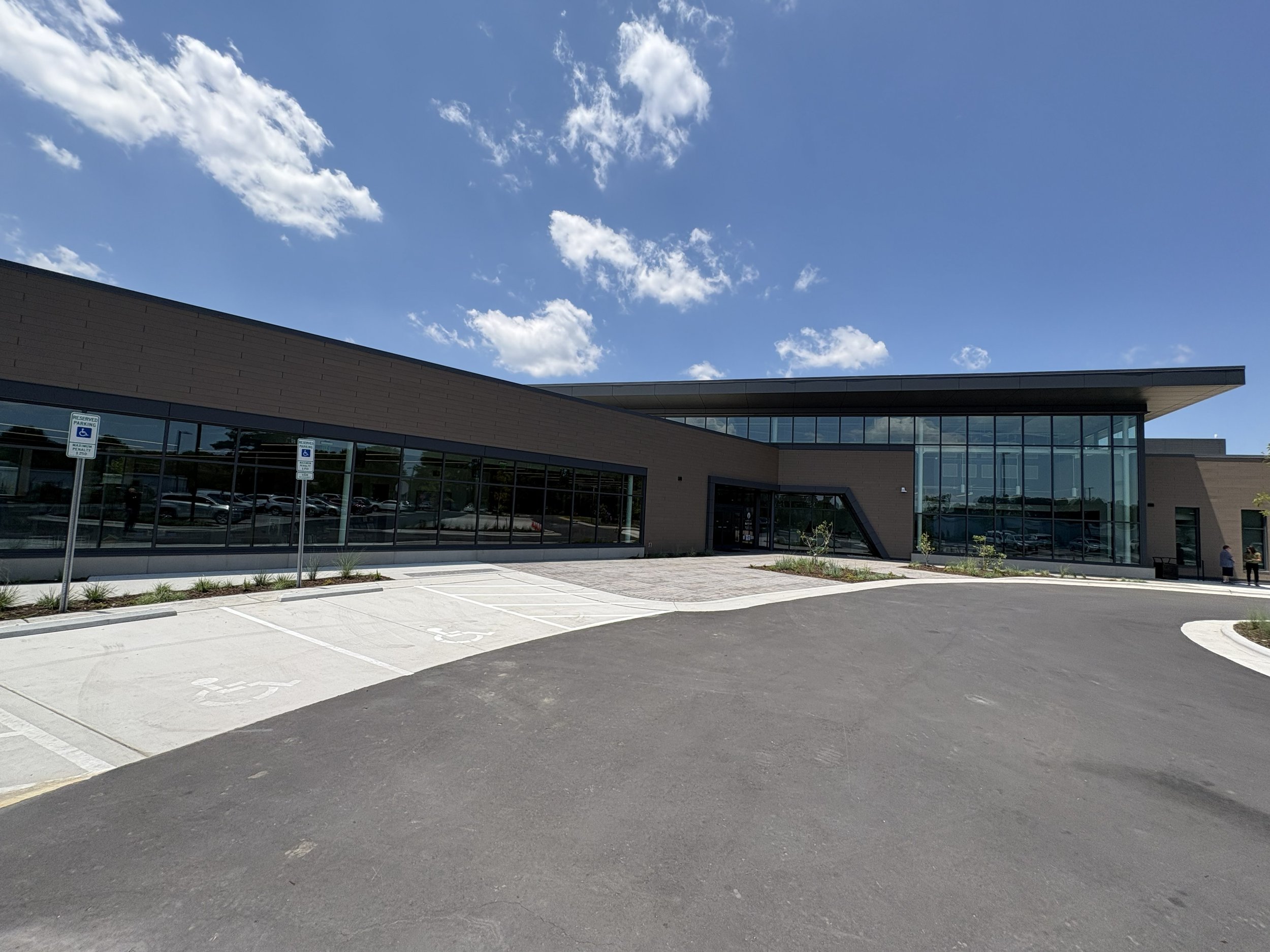modern L-shaped building of glass and dark brown brick