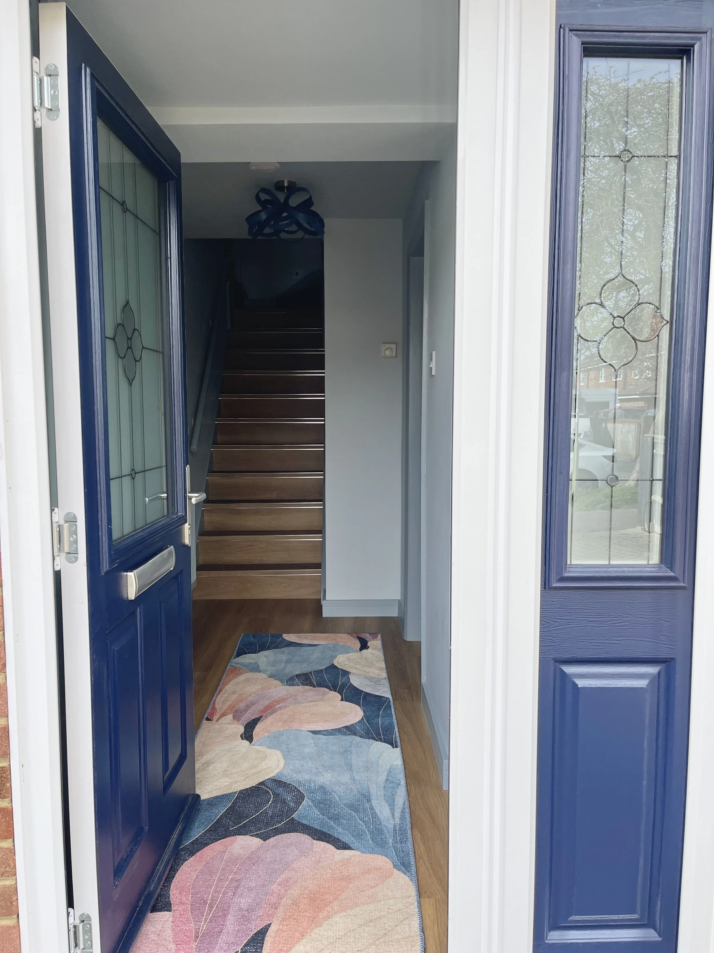 Narrow entrance hallway with blue walls, patterned runner