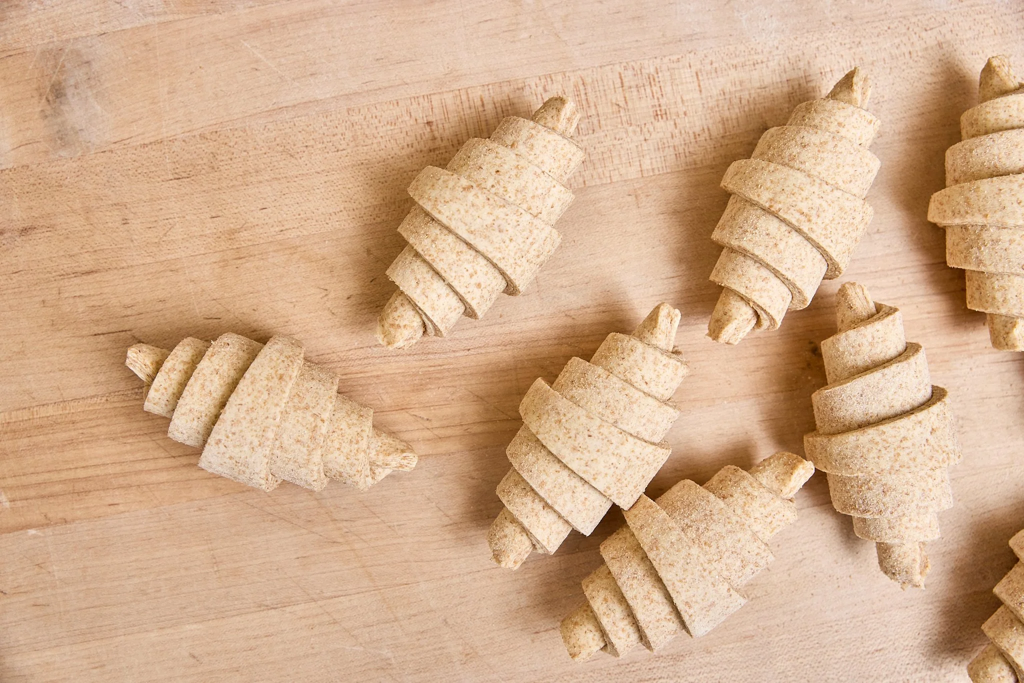 Several spiral-shaped raw ingredients on a wooden surface, likely frozen truffles or a similar root vegetable.