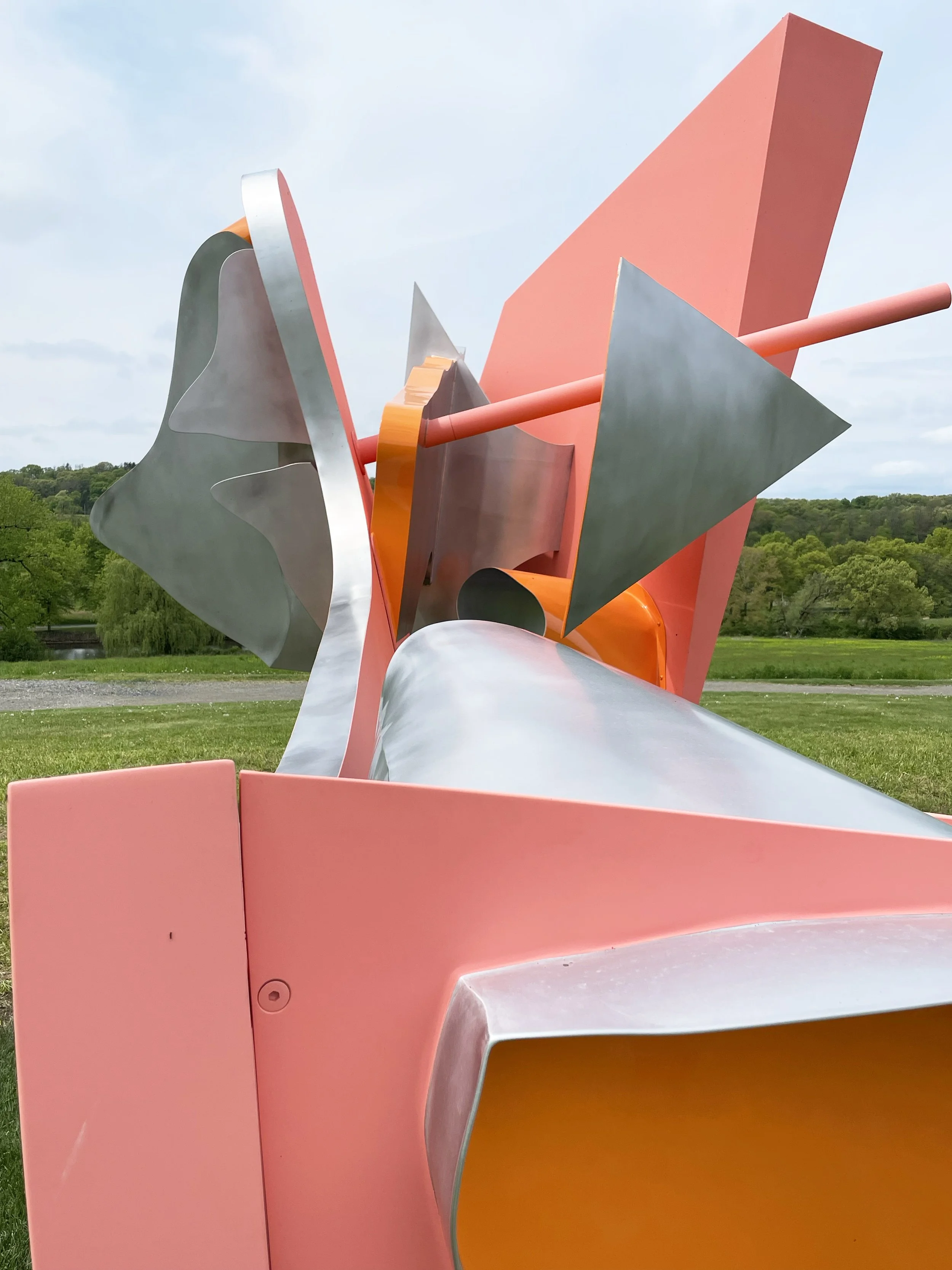 large metal sculpture with coral and mango colors