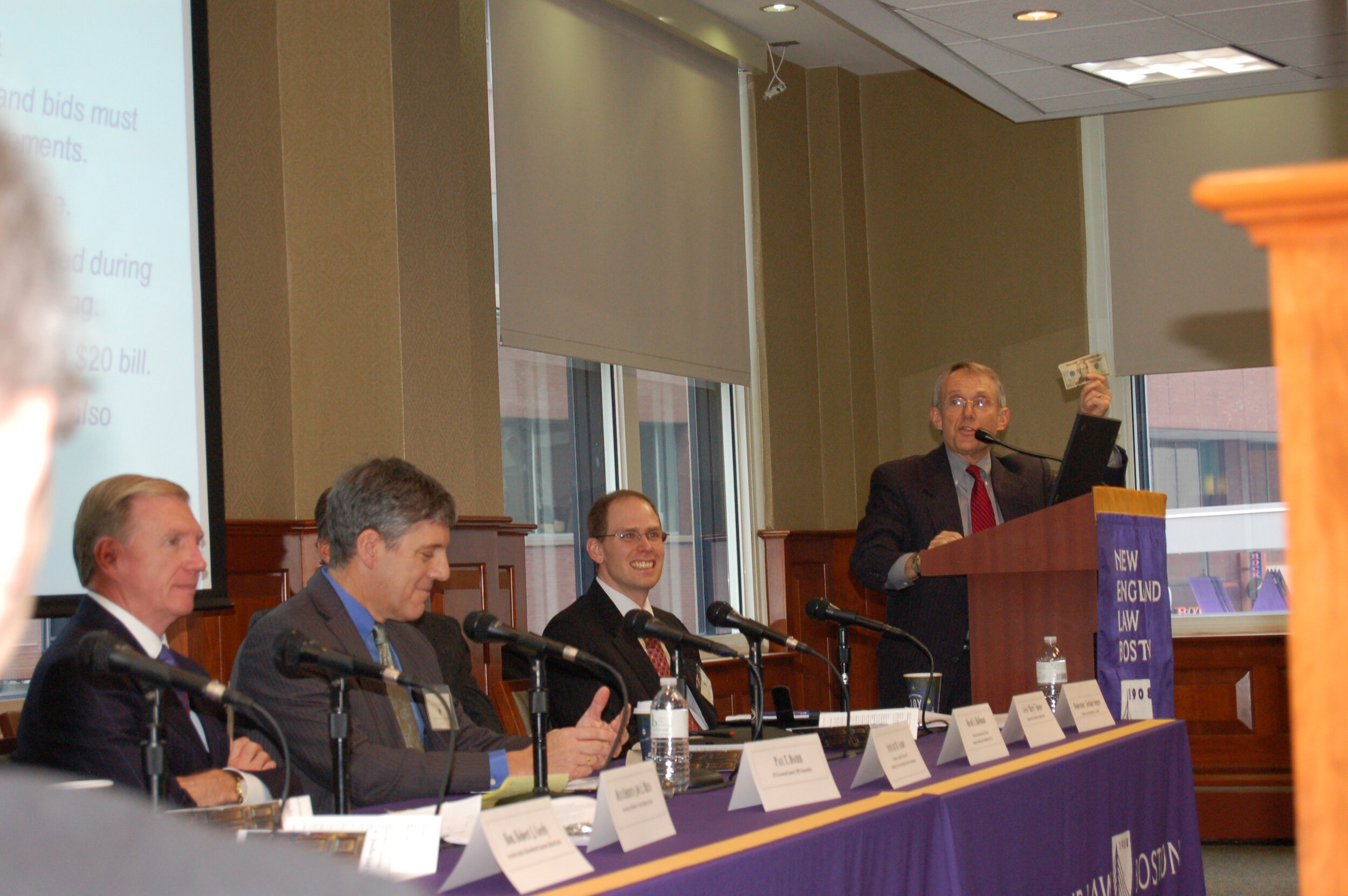  Prof. David Hoffman of Harvard Law School gestures at the podium. Seated from left to right: Paul Dacier, Stewart Aaron, Harry Spence (hidden), and Prof. Jordan Singer. 