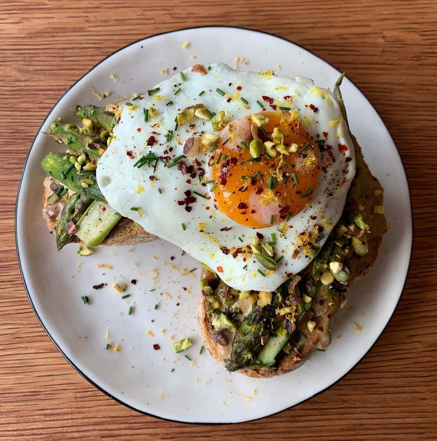 Toast asparagus on a caramelized onion dip topped with pistachios, chilli and lemon zest.🍋🍽️ Add a sunny egg on top for extra yummyness 🍳🙌