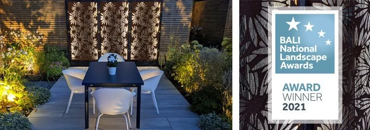 Outdoor patio with a black table, white chairs, and decorative plants, featuring a Bali National Landscape Awards 2021 winner plaque.