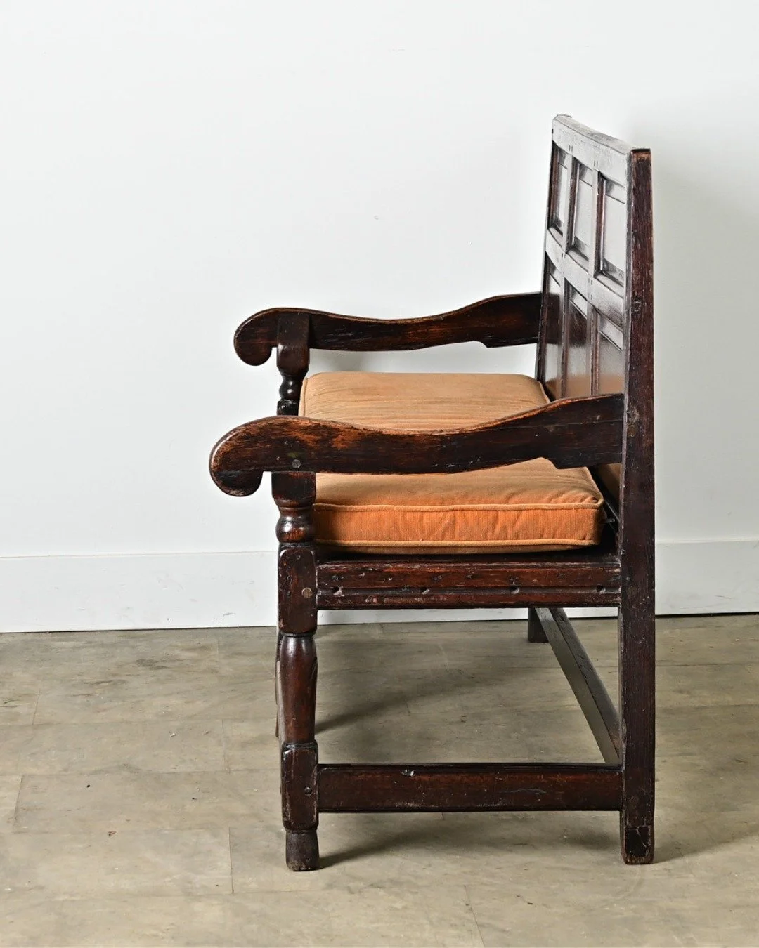 English 18th Century Oak Hall Bench, circa 1780, with paneled back that carries nearly three centuries of dark patina. With gently scrolling arms, turned pad feet &amp; removable cinnamon velvet cushion, it&rsquo;s a timeless piece where form meets f