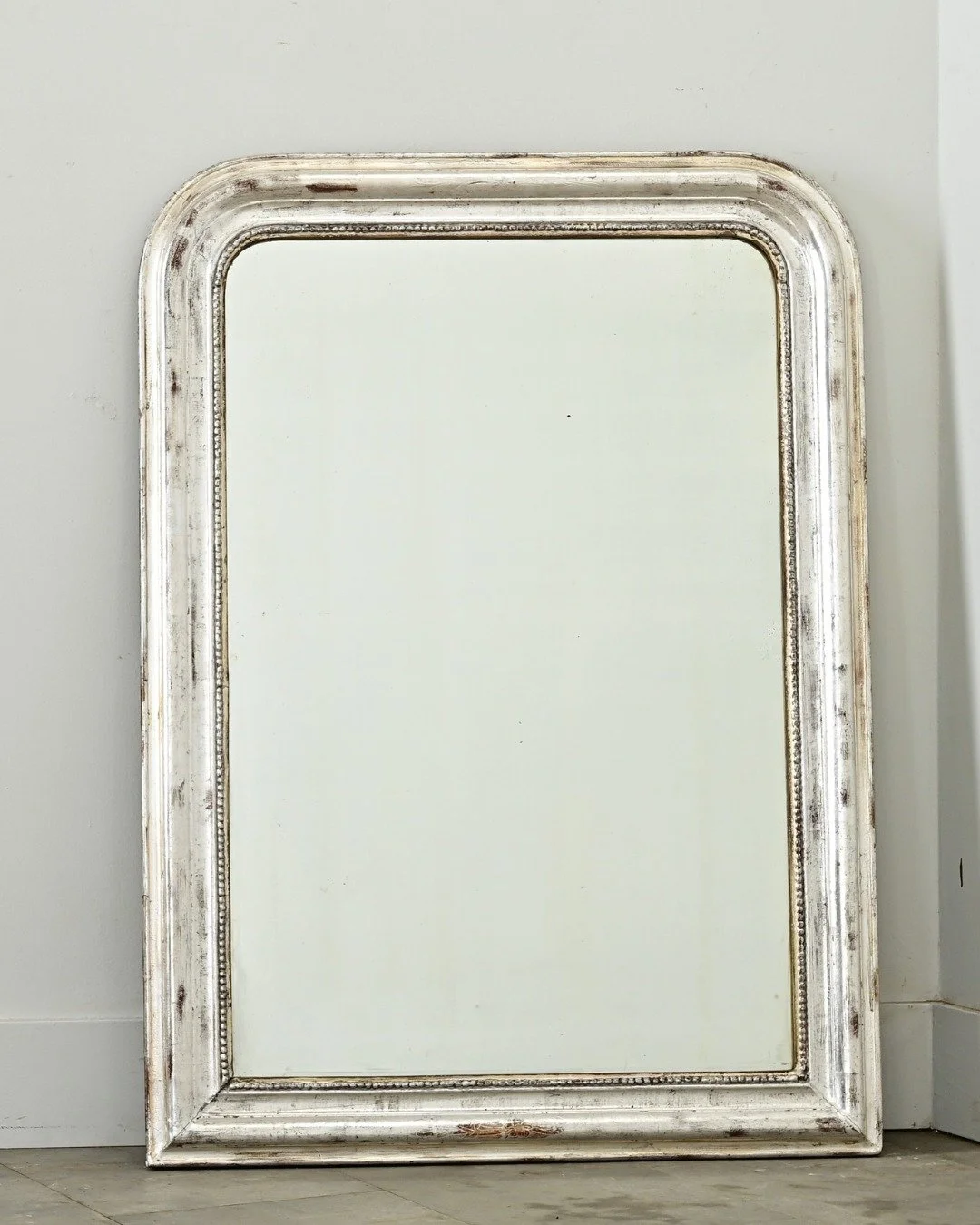 French 19th Century Silver Gilt Louis Philippe Mirror with understated, silver gilt frame enhanced by dark oxidation &amp; craquelure texture. Holding the original mirror plate with areas of light foxing, outlined in beaded &ldquo;pearl&rdquo; trim.
