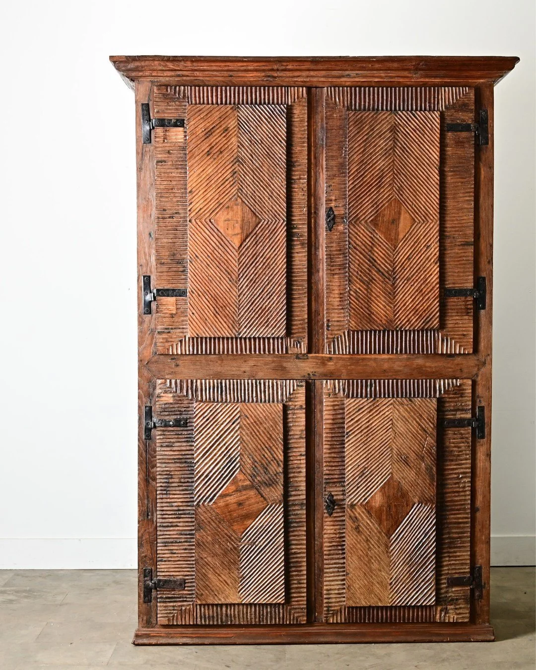A substantial Portuguese 18th Century Carved Solid Chestnut Cabinet, 18th century if not earlier, carefully transformed with reeded geometric designs on the four doors. In a hybrid style known as &ldquo;Mud&eacute;jar&rdquo; the decorative arts of th