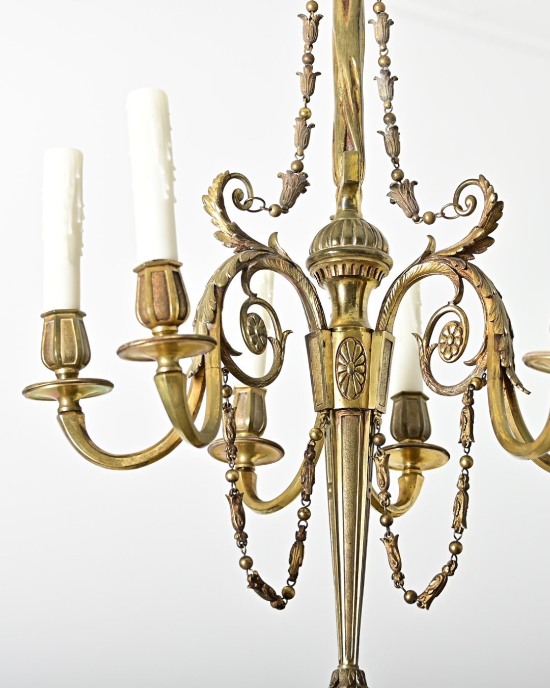 French 19th Century Gilt Bronze Chandelier accented with dainty foliate &amp; Neoclassical motifs in lieu of crystals. The slender fixture incorporates a crown of plumes from which the column descends, cast with slightly ruched texture to mimic the f