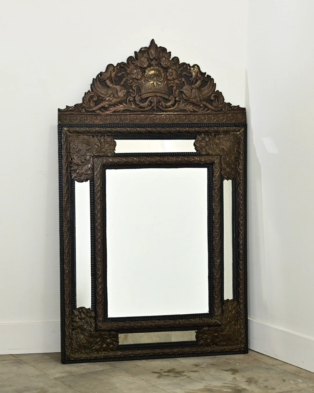 French 19th Century Napoleon III Cushion Mirror punched from a metal plate to high relief for exciting dimension, with mythical sea serpents &amp; dense foliate patterns covering the rectangular form. This narrative mirror in the Napoleon III style f