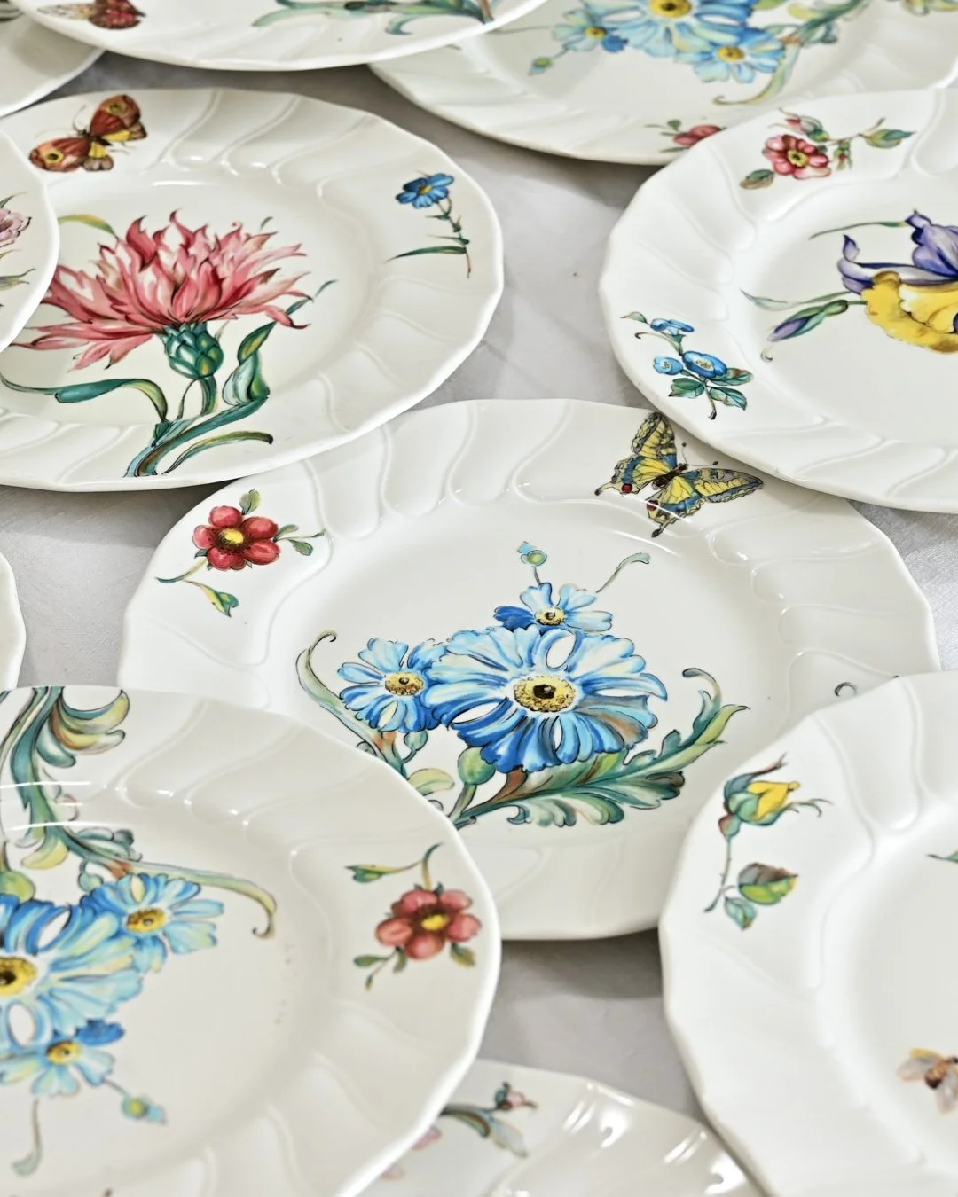 Charming Vintage Twenty-Eight Piece Set by Villeroy &amp; Boch in the &ldquo;Bouquet&rdquo; pattern of colorful floral illustrations on white background that highlights the different blossoms featured on each piece: delphinium, poppy, tulip, and this