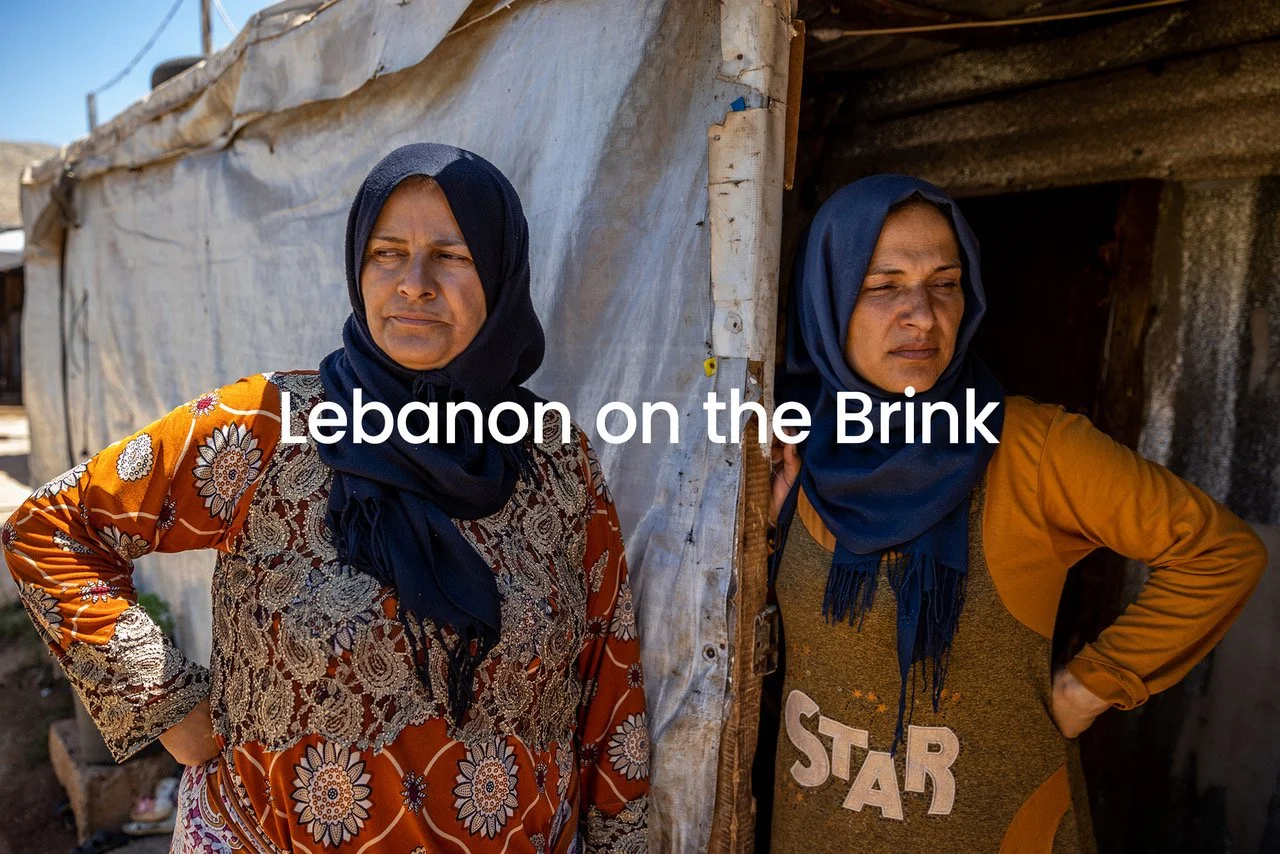 Two women wearing headscarves standing at the entrance of a makeshift shelter in Lebanon, with the words 'Lebanon on the Brink' overlaid on the image.