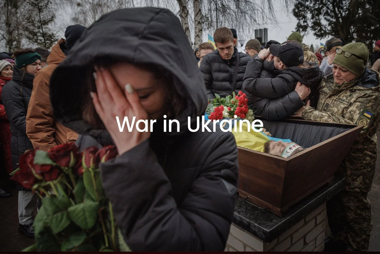 People mourning at a funeral for a victim of the Ukraine war, with some embracing and others grieving over a coffin