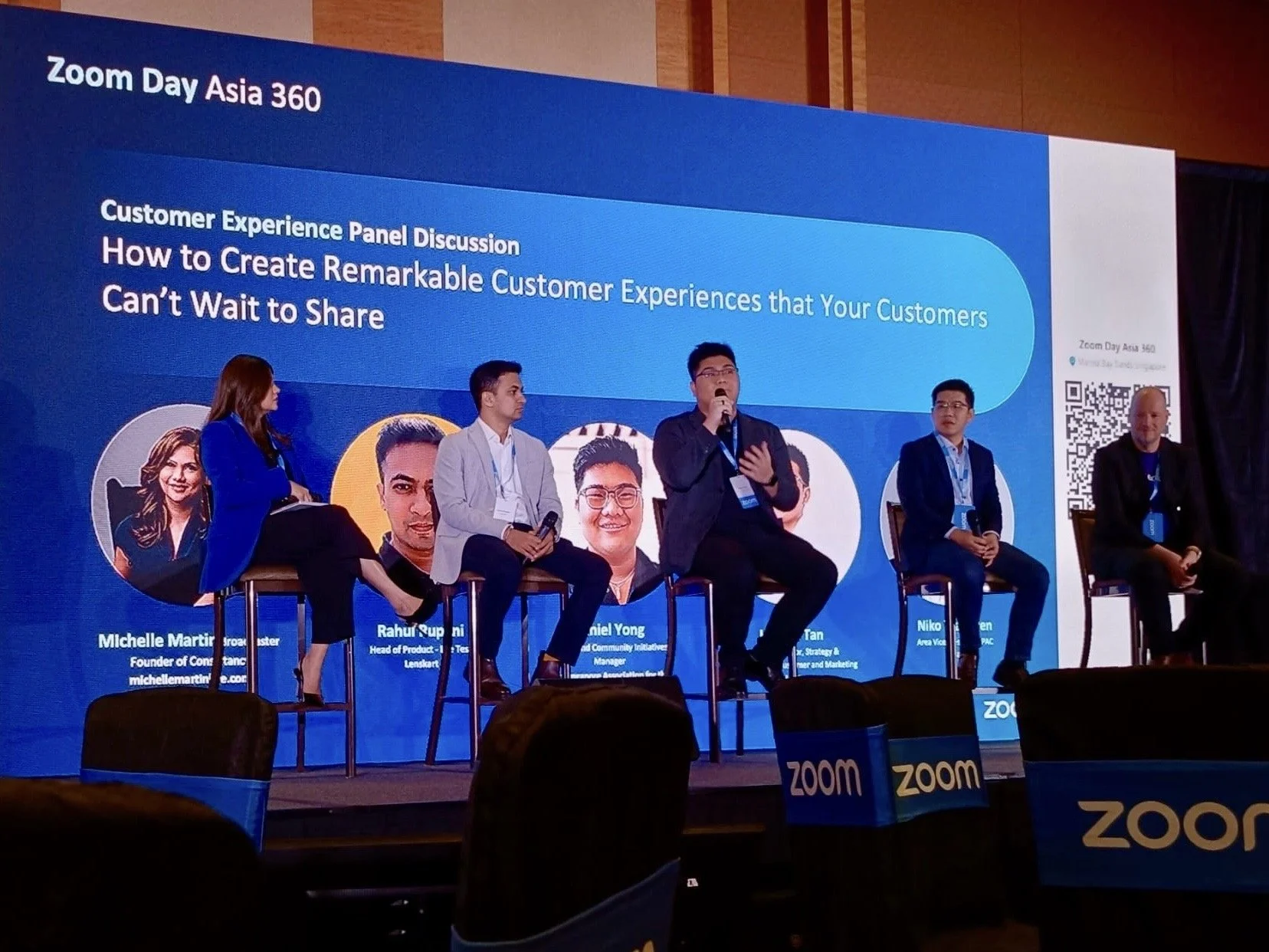 Daniel, along with 2 others, speak on a panel on stage.