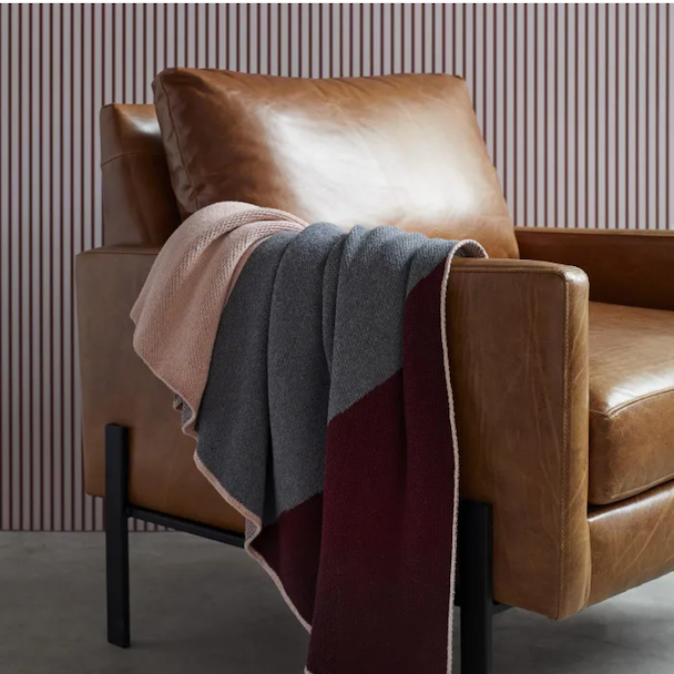 Red wine and grey throw blanket over a chair
