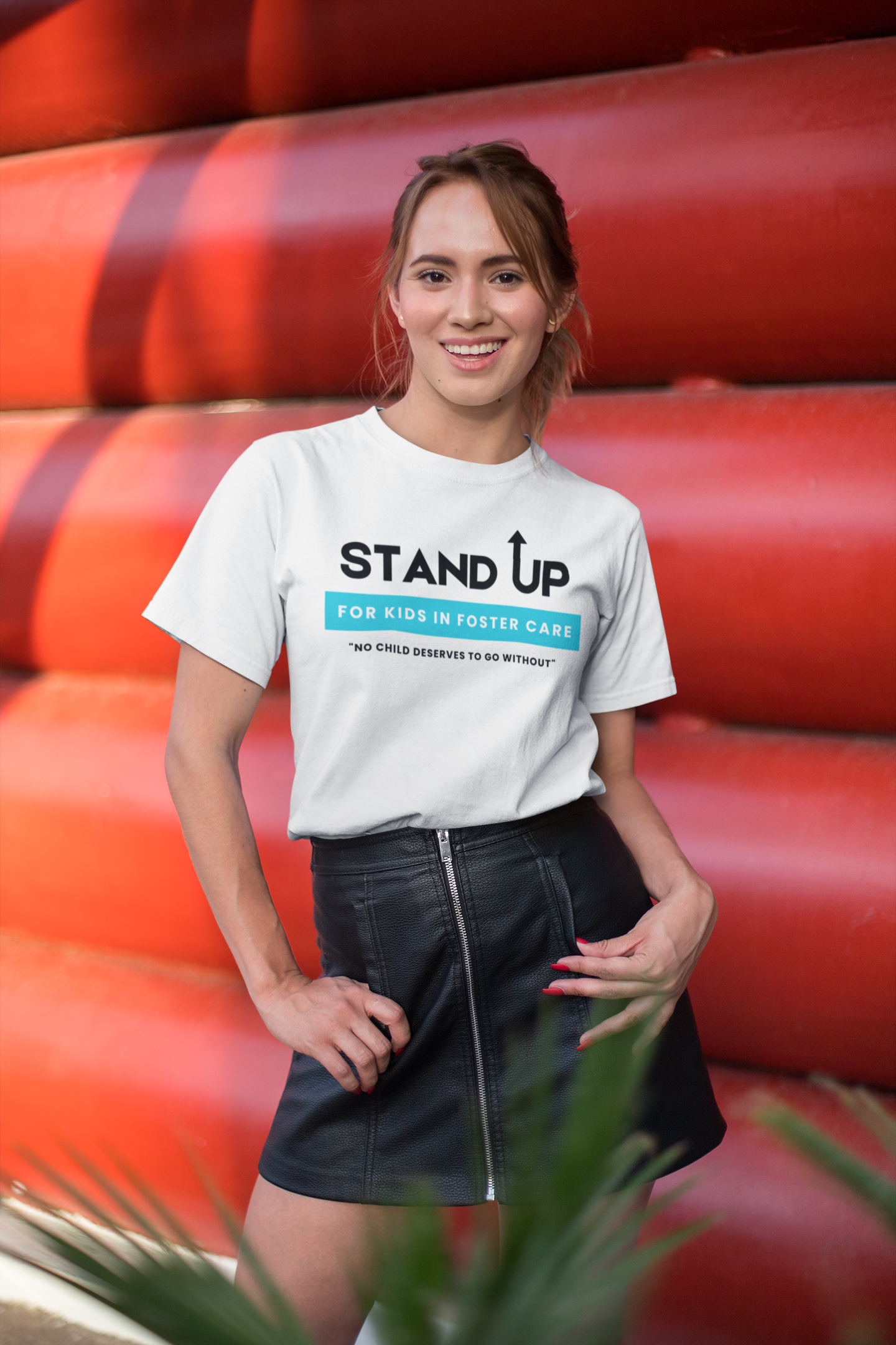 tee-mockup-of-a-smiling-woman-standing-in-front-of-a-red-structure-26649.png