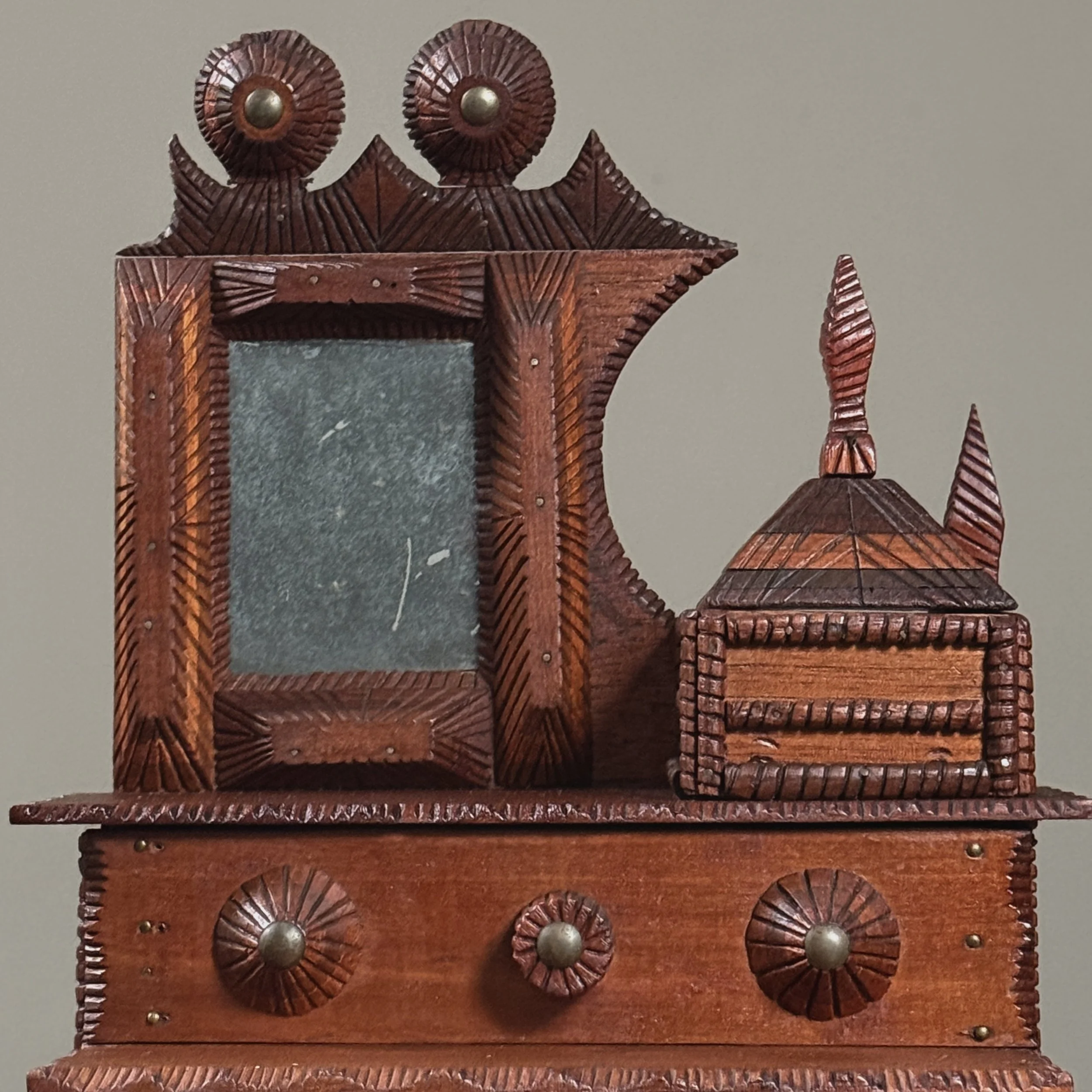 Close-up of framed mirror with round carved ornamentation