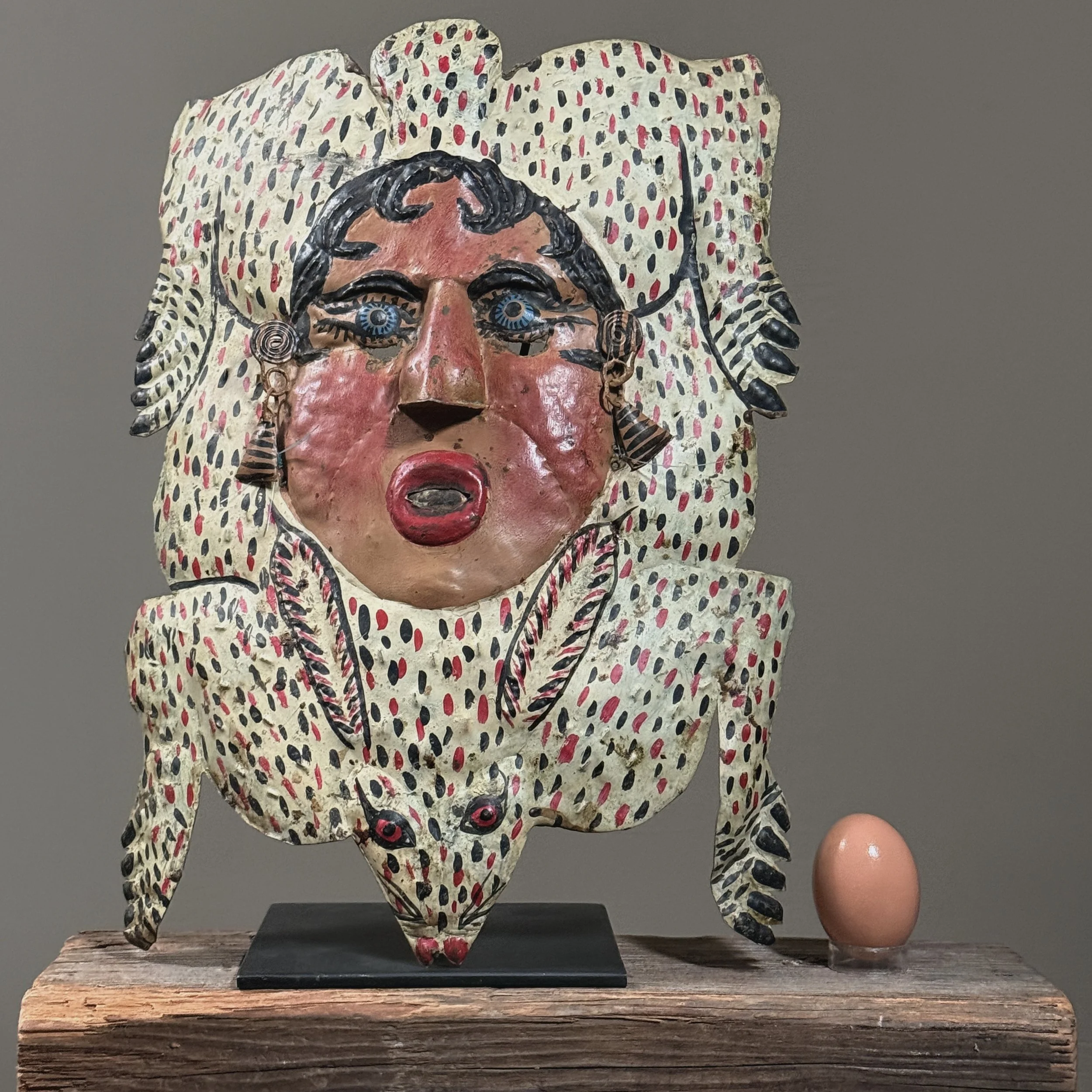 Hand-painted copper mask with sculptural rabbit and woman’s face with egg for size reference.