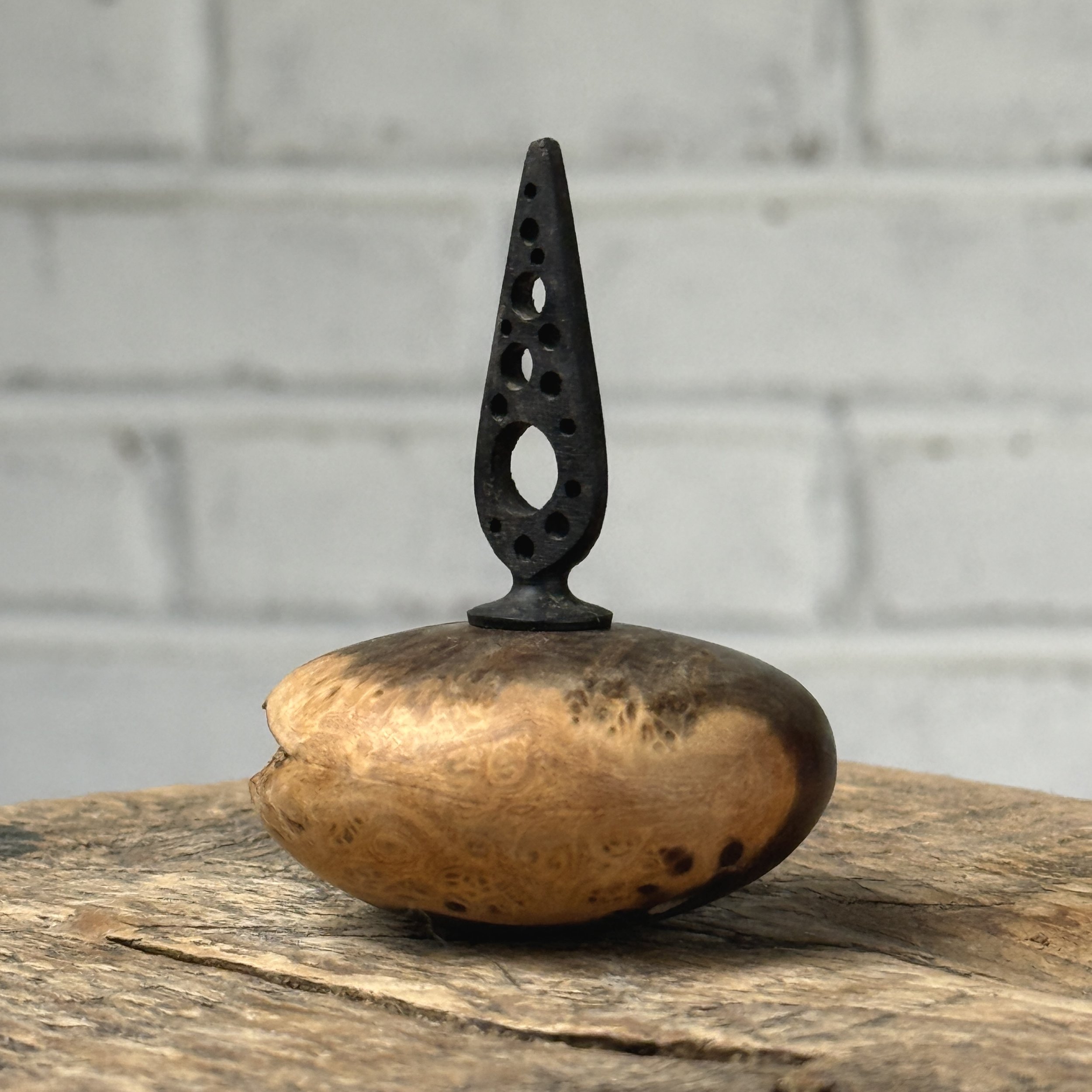 Vintage miniature turned burl wood vessel with hand-carved ebony topper on white background