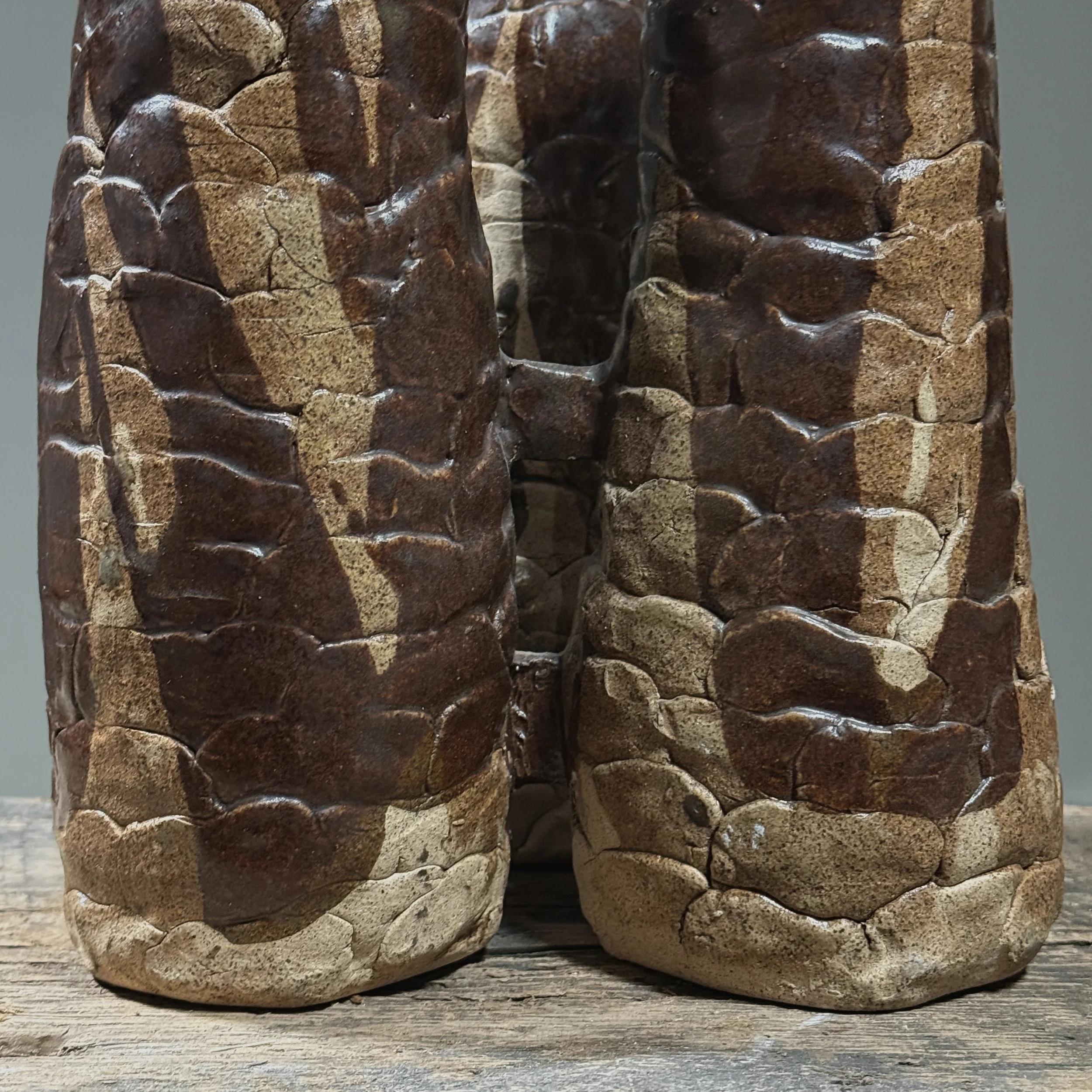Close-up detail of hand-built construction and textured brown glaze on a Brutalist ceramic vessel