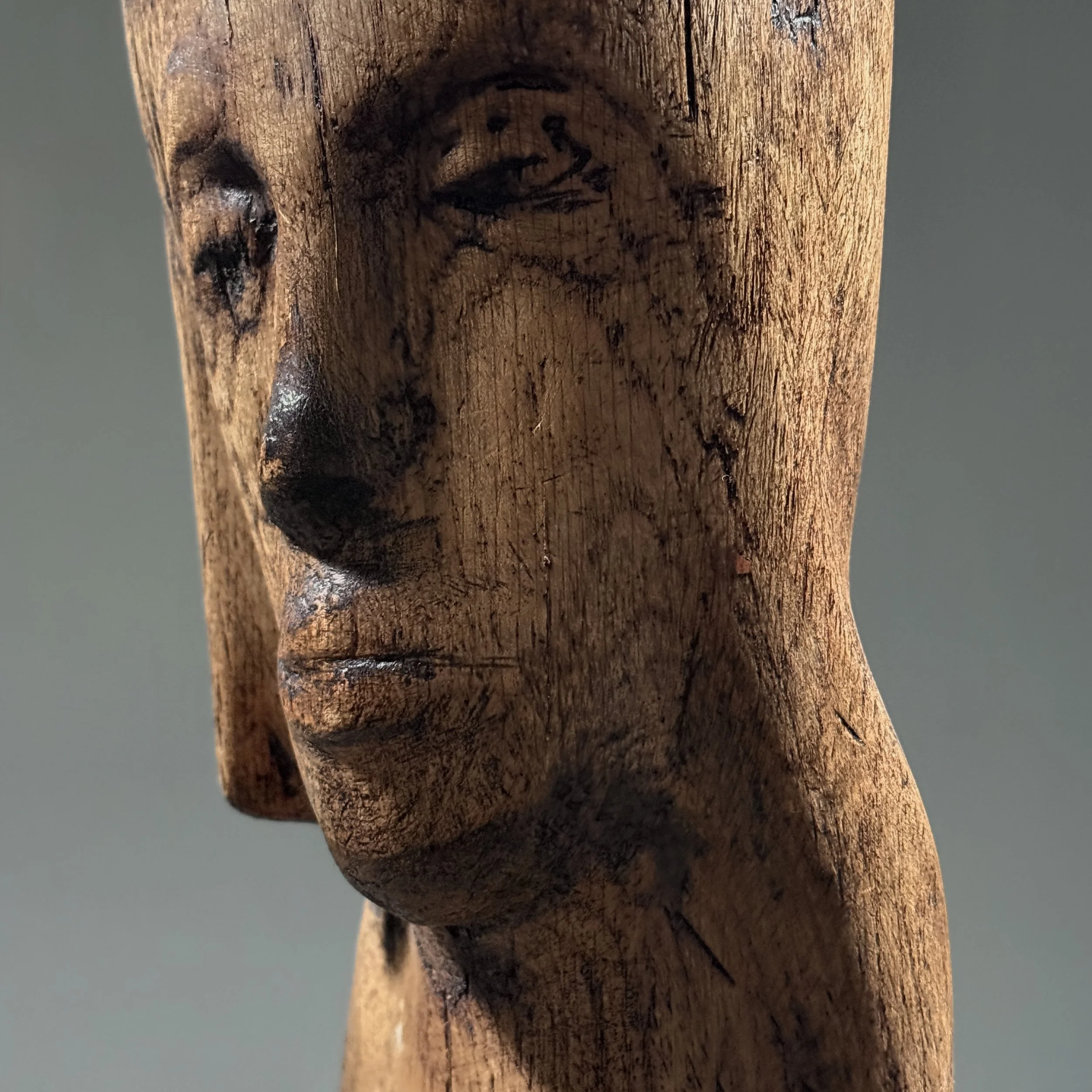 Close-up detail of face and carving on vintage hand carved Folk Art Modernist portrait bust, wood