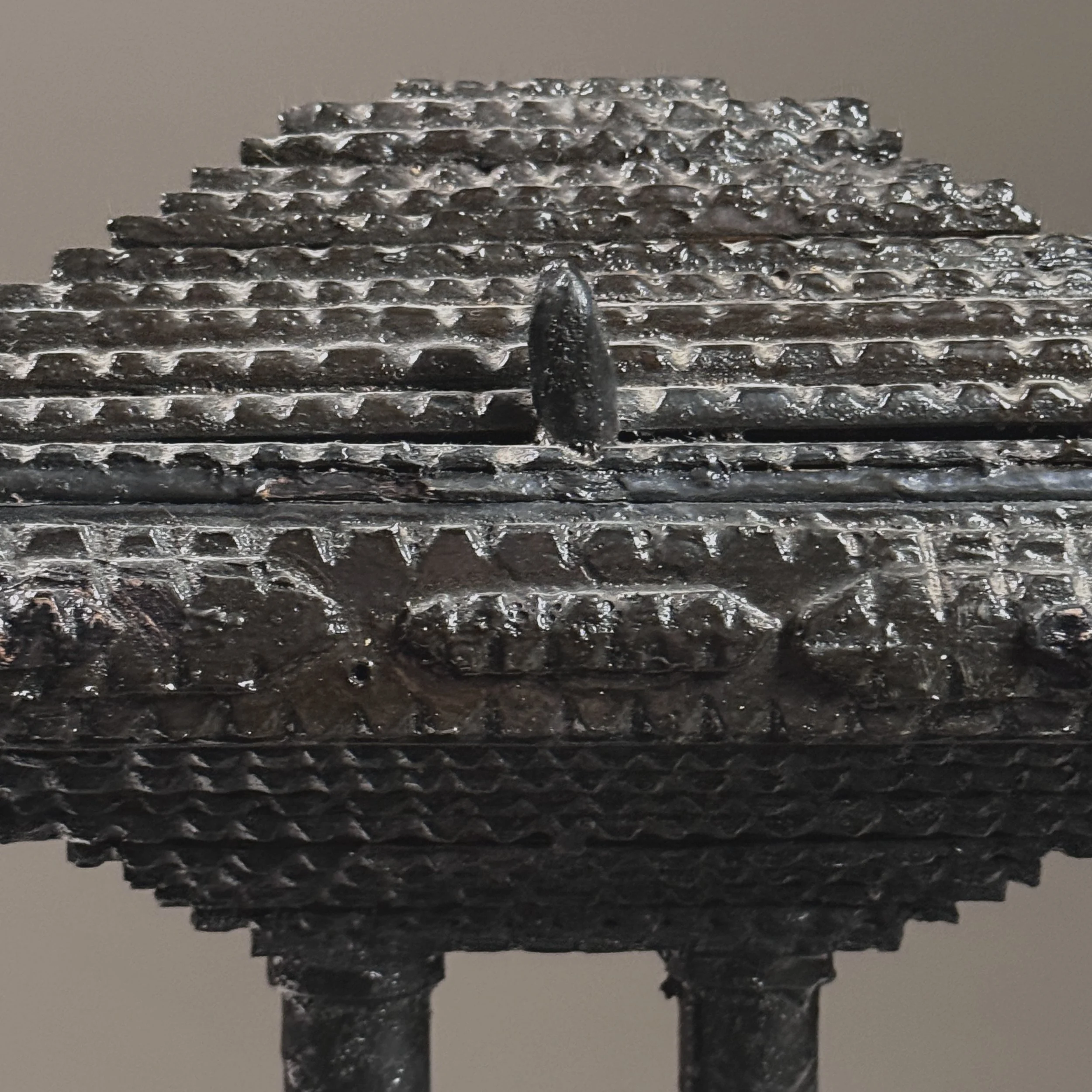 Macro detail of chip-carving technique and black painted finish with age-appropriate wear