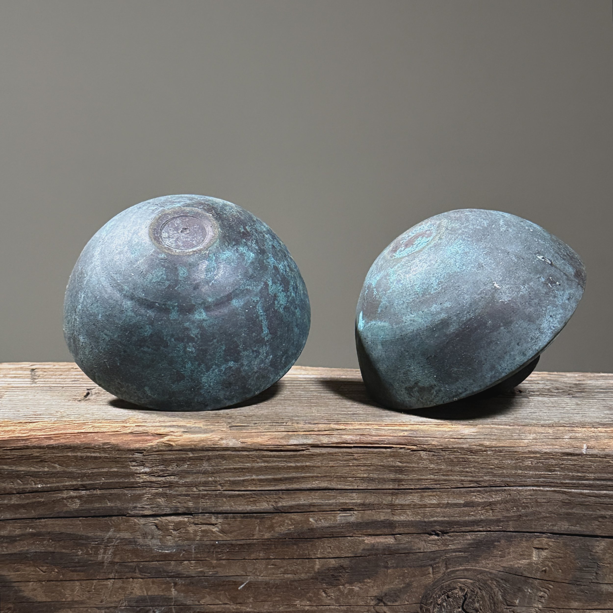 Bottom view of vintage Brutalist metal candle holder pair, verdigris patina, each 4.38 inches diameter by 3.25 inches height.