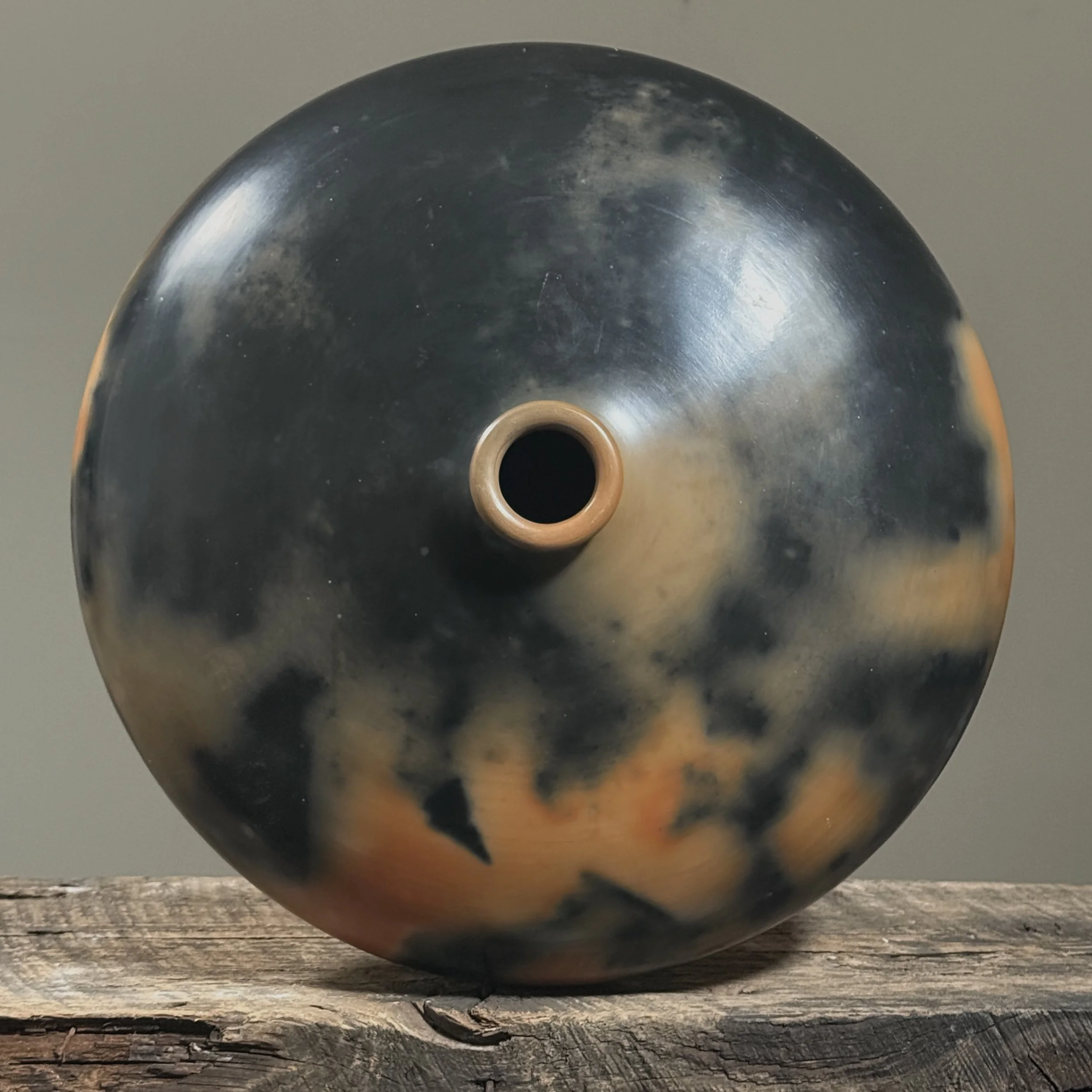 Wide rounded form of smoke-fired seed pot shown from above.