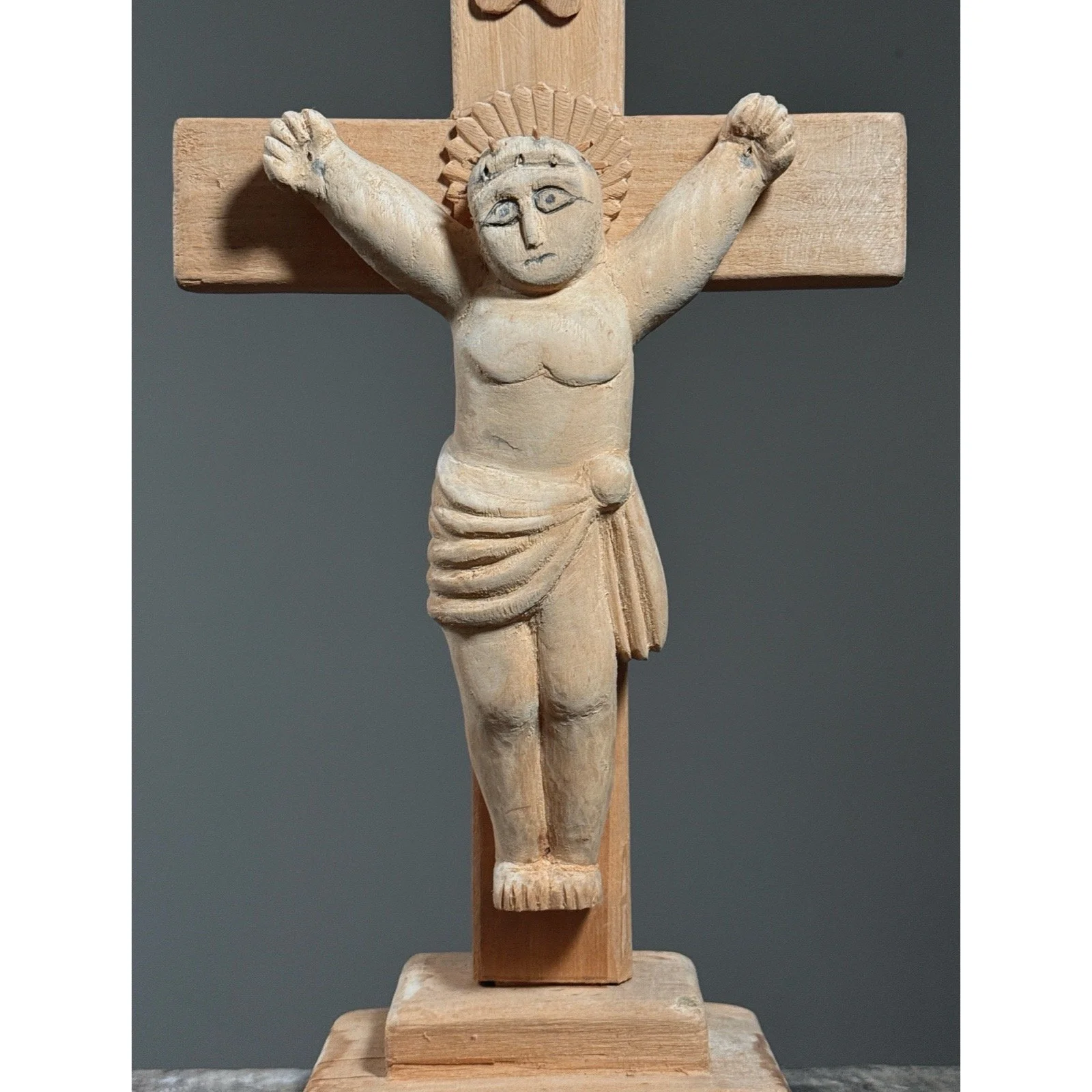 Folk art crucifix showing carved figure of Christ on cross