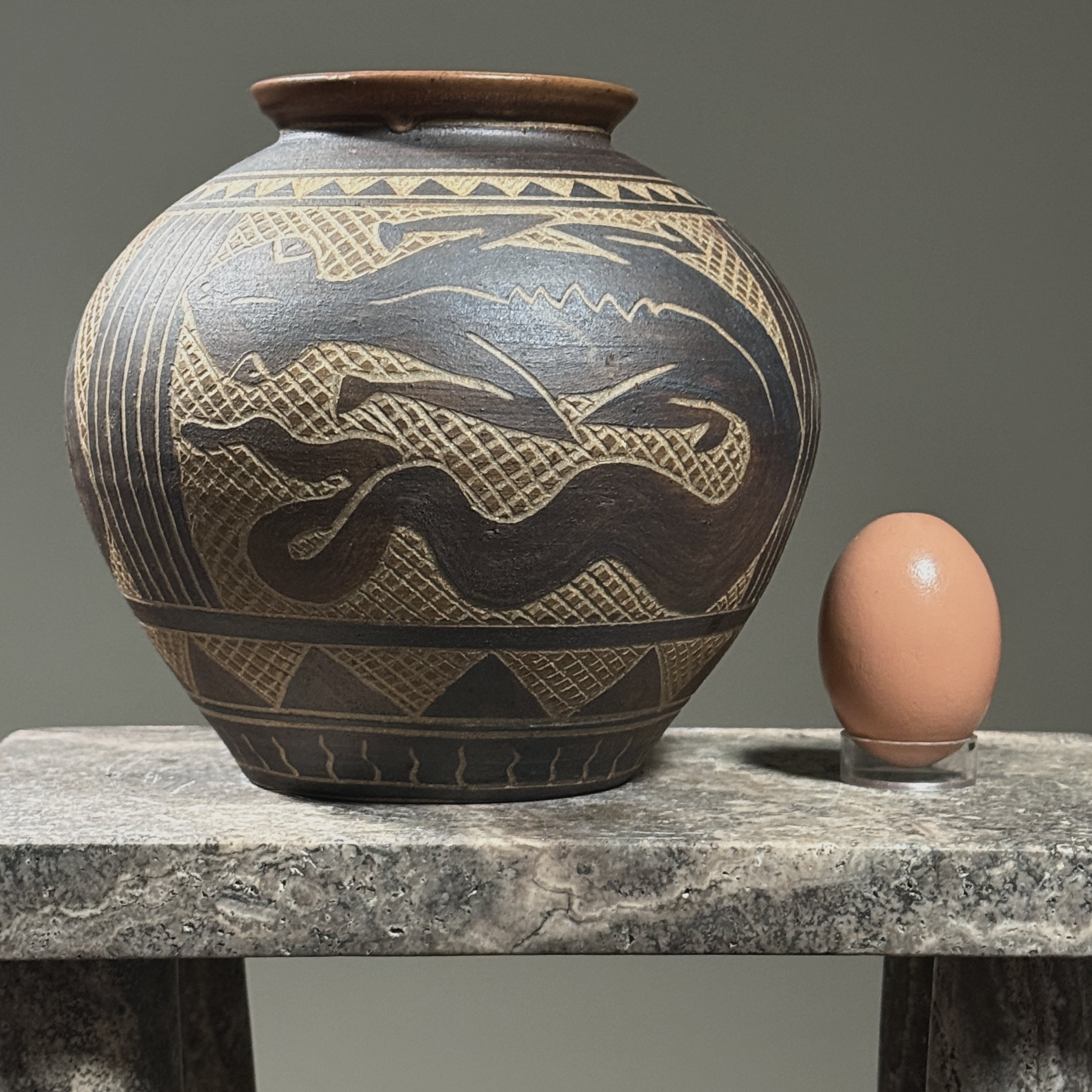 Vintage folk art sgraffito vase with lizard design with egg for size reference.