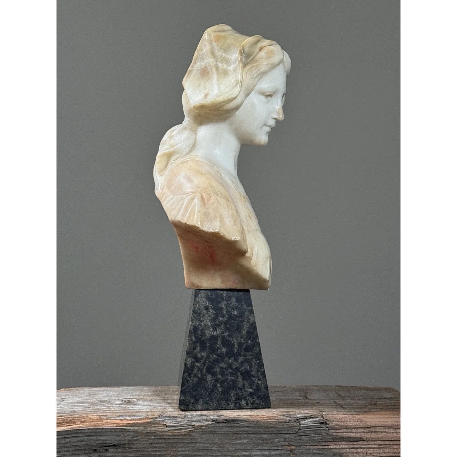 Side view illustrating the relationship between the alabaster bust and the stone stand.