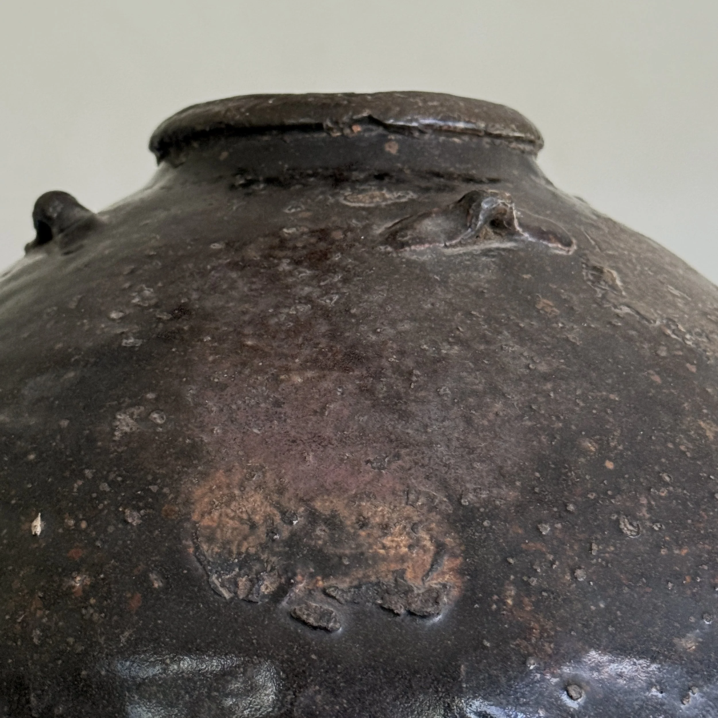 Detail of glaze texture and patina on 17th century vessel In daylight.