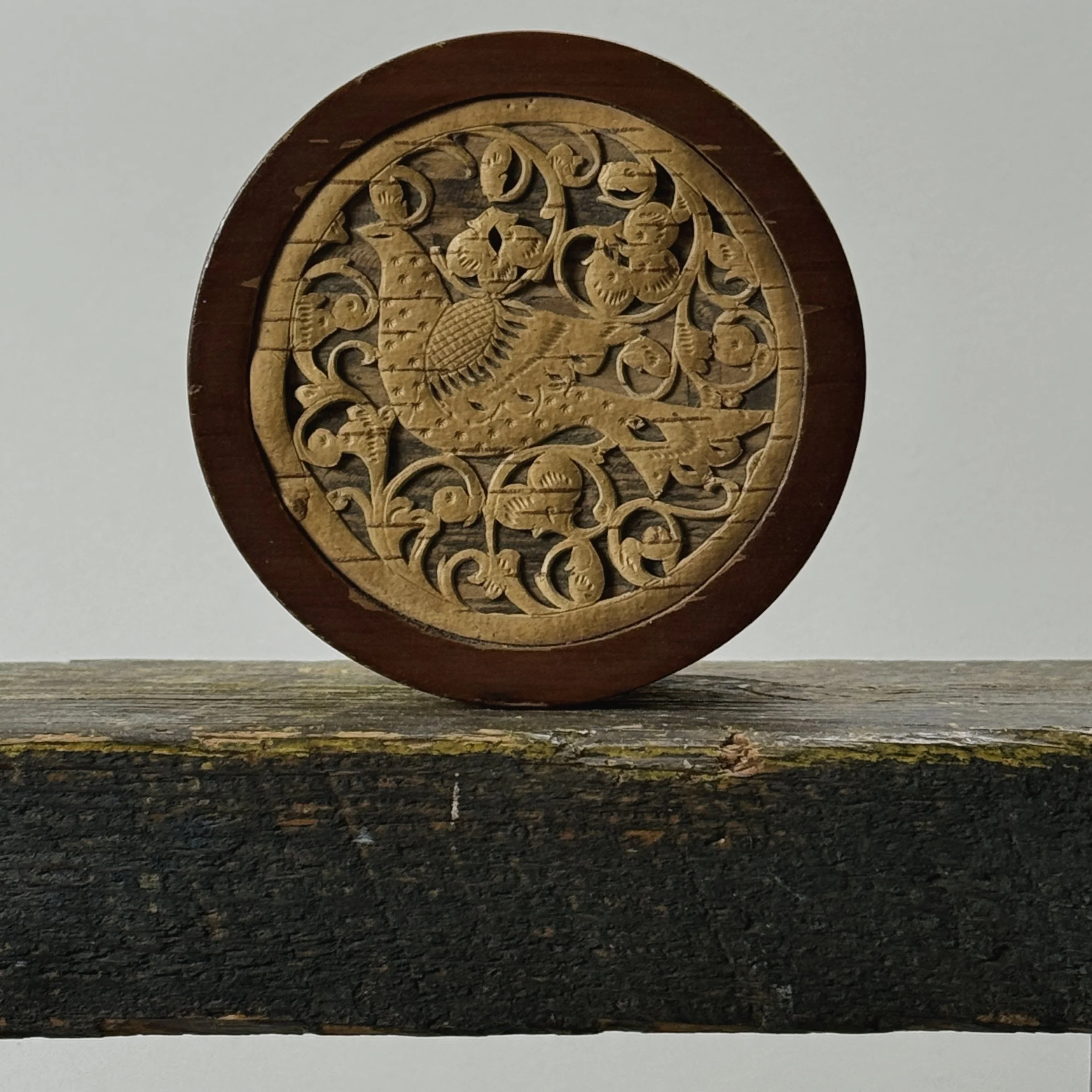 Lid detail of carved bird surrounded by fretwork foliage