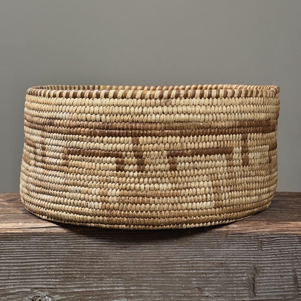 Front view of an antique Pima coiled basket with high straight walls.
