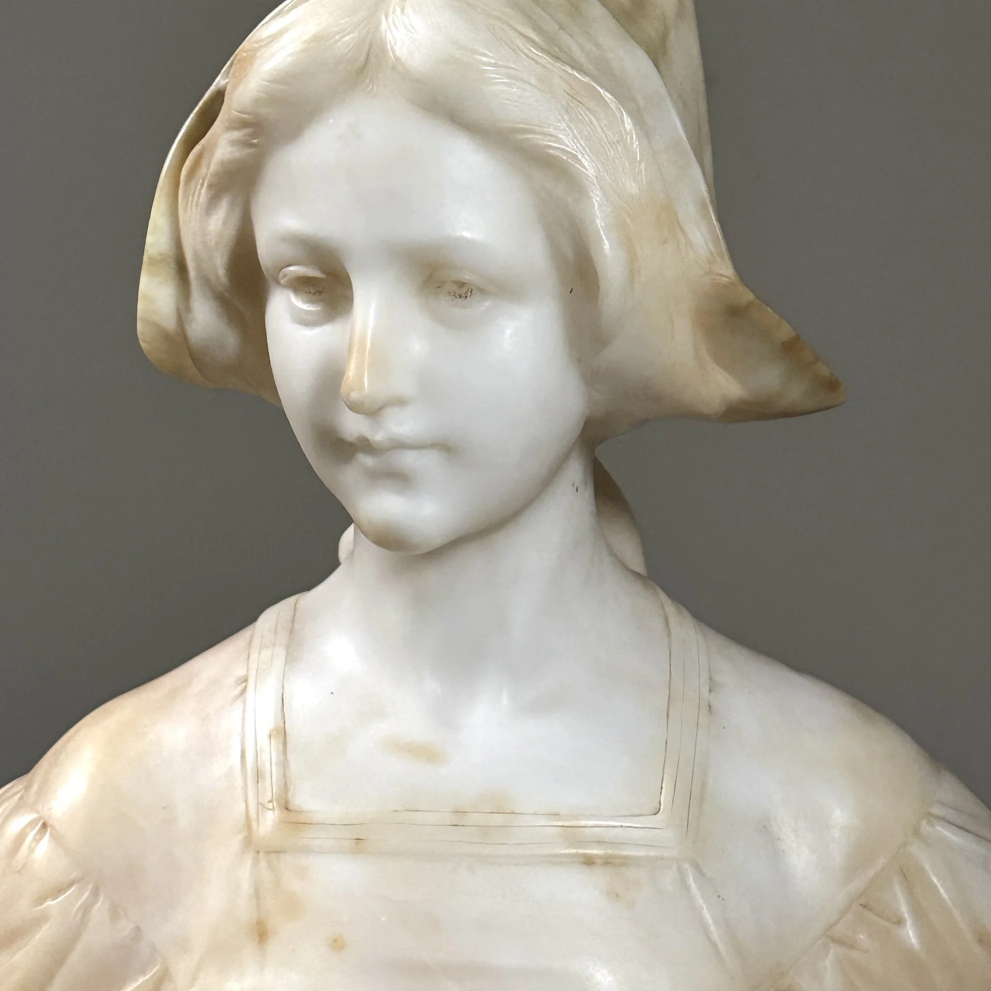 Close-up detail of the woman's softly carved facial features and expression.