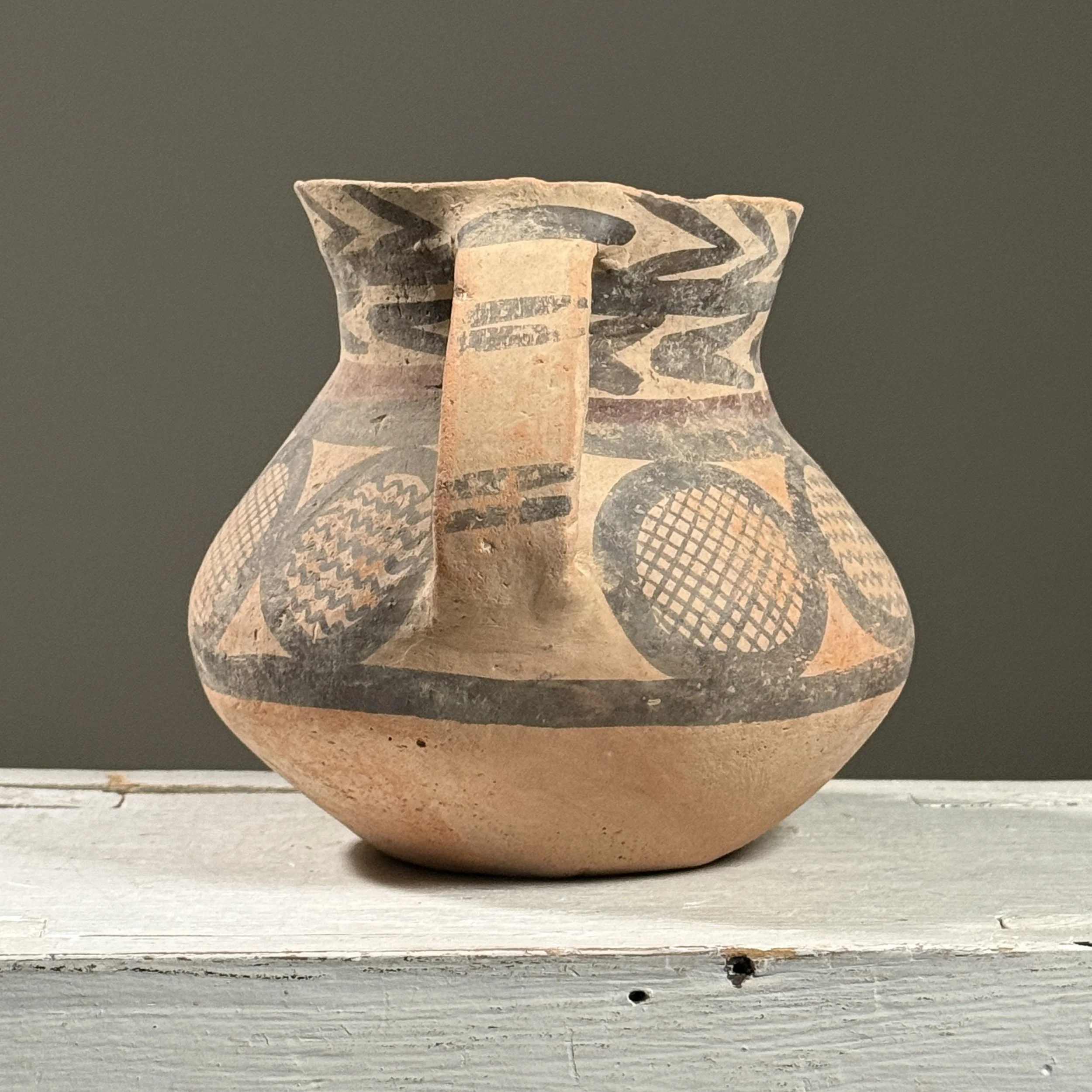Full frontal view of a Chinese Neolithic style pottery jar with bulbous body and flaring neck