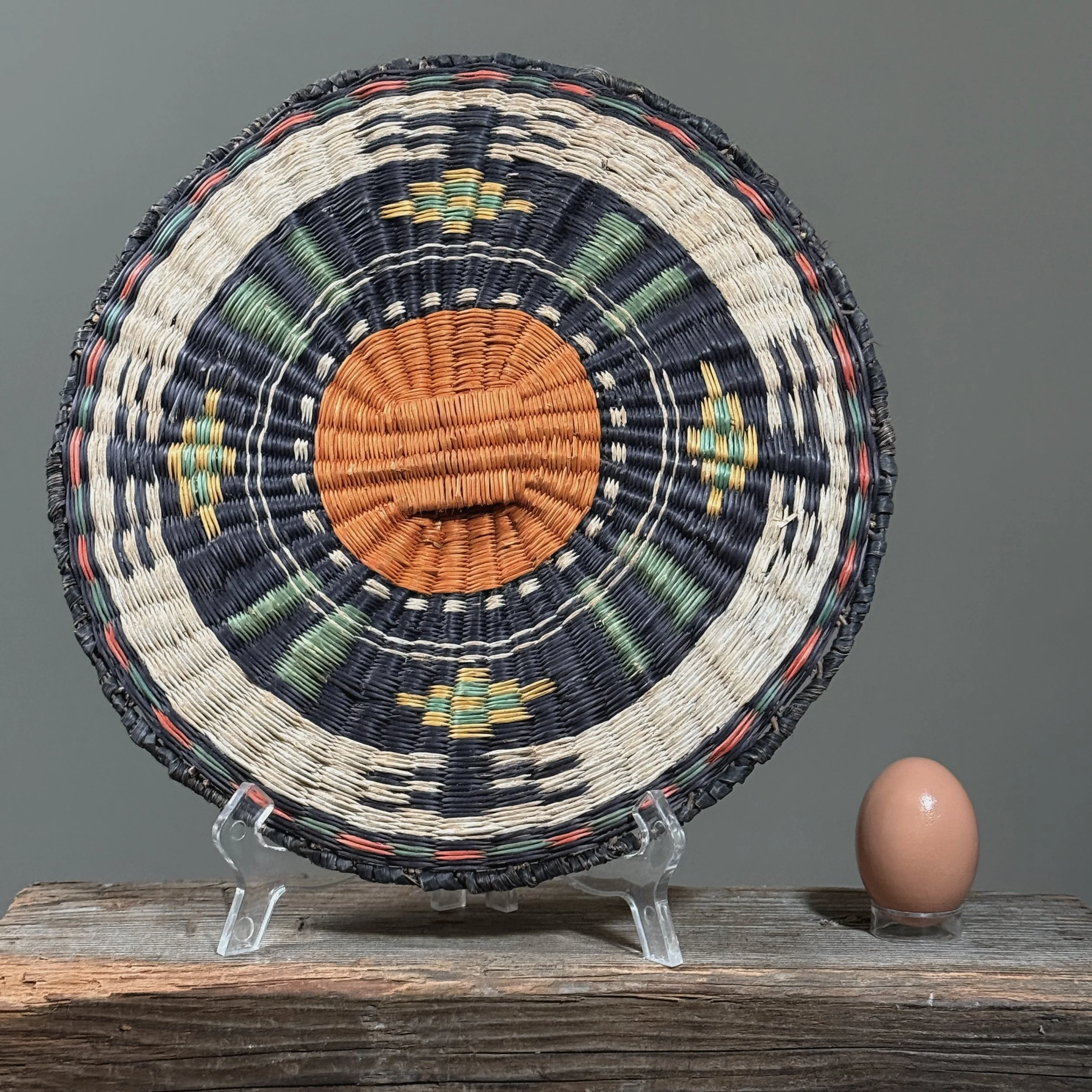 Front view of a vintage Hopi Third Mesa wicker plaque, circa 1950 with egg for size reference.